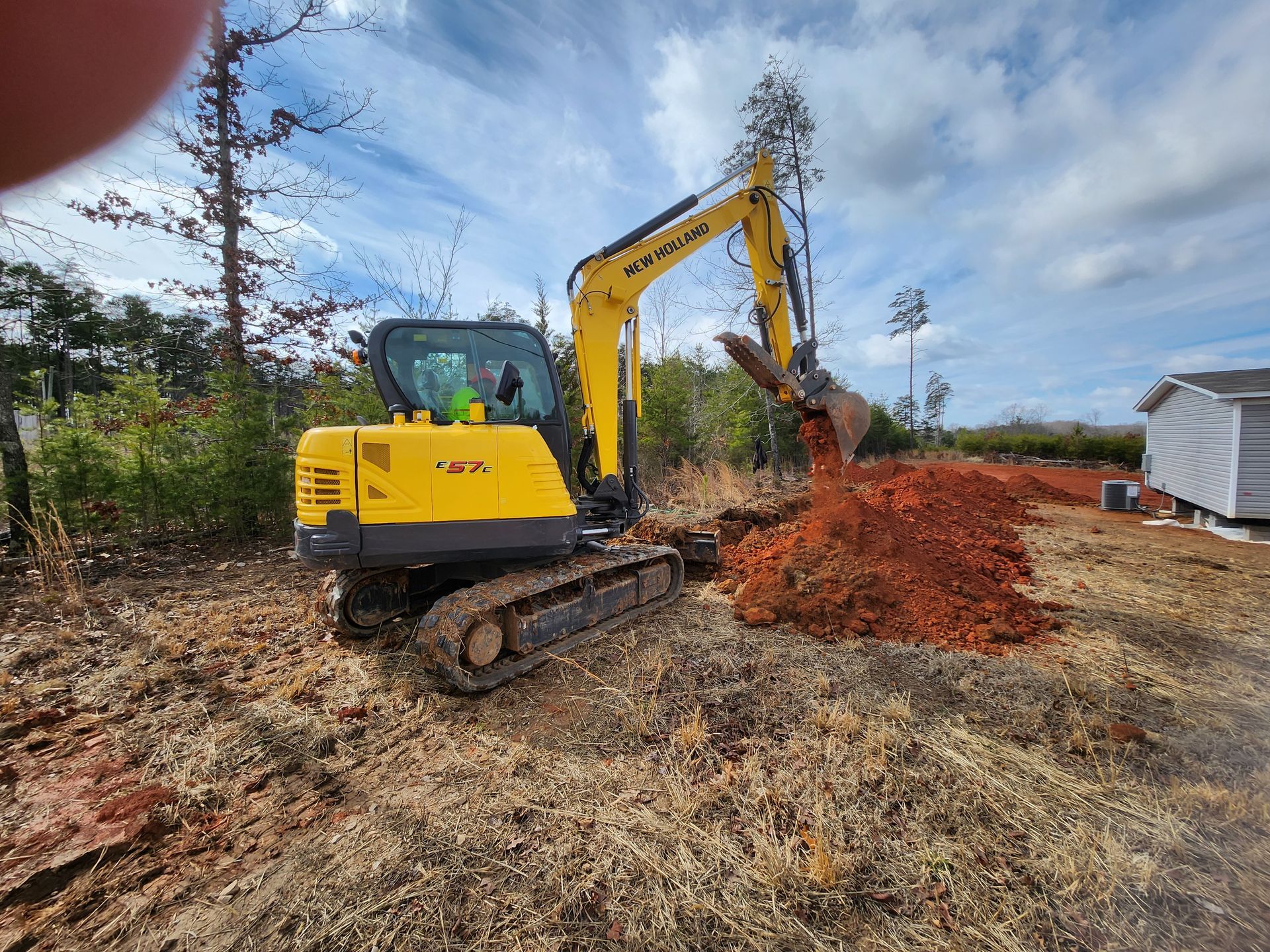 A yellow excavator is digging a hole in the dirt.