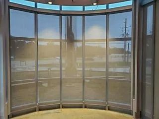 Curved glass lobby windows with a bright snowy outdoor view