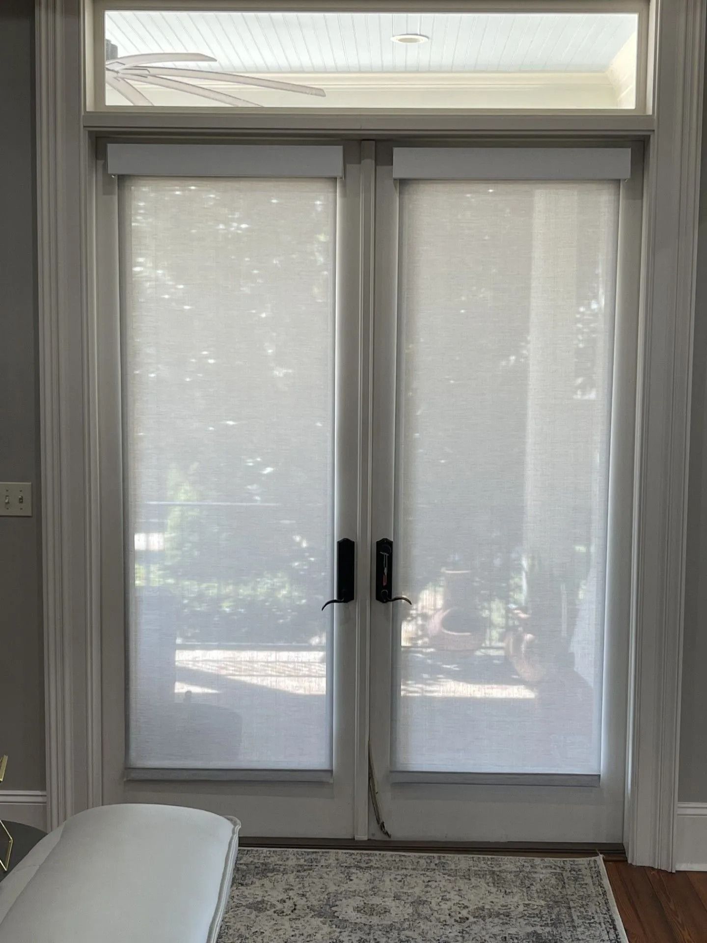 White French doors with sheer blinds and daylight filtering through, viewed from inside a room