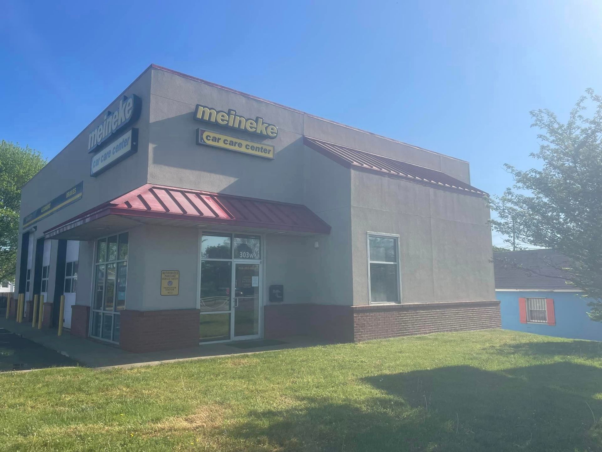 A large building with a red awning is sitting on top of a lush green field.