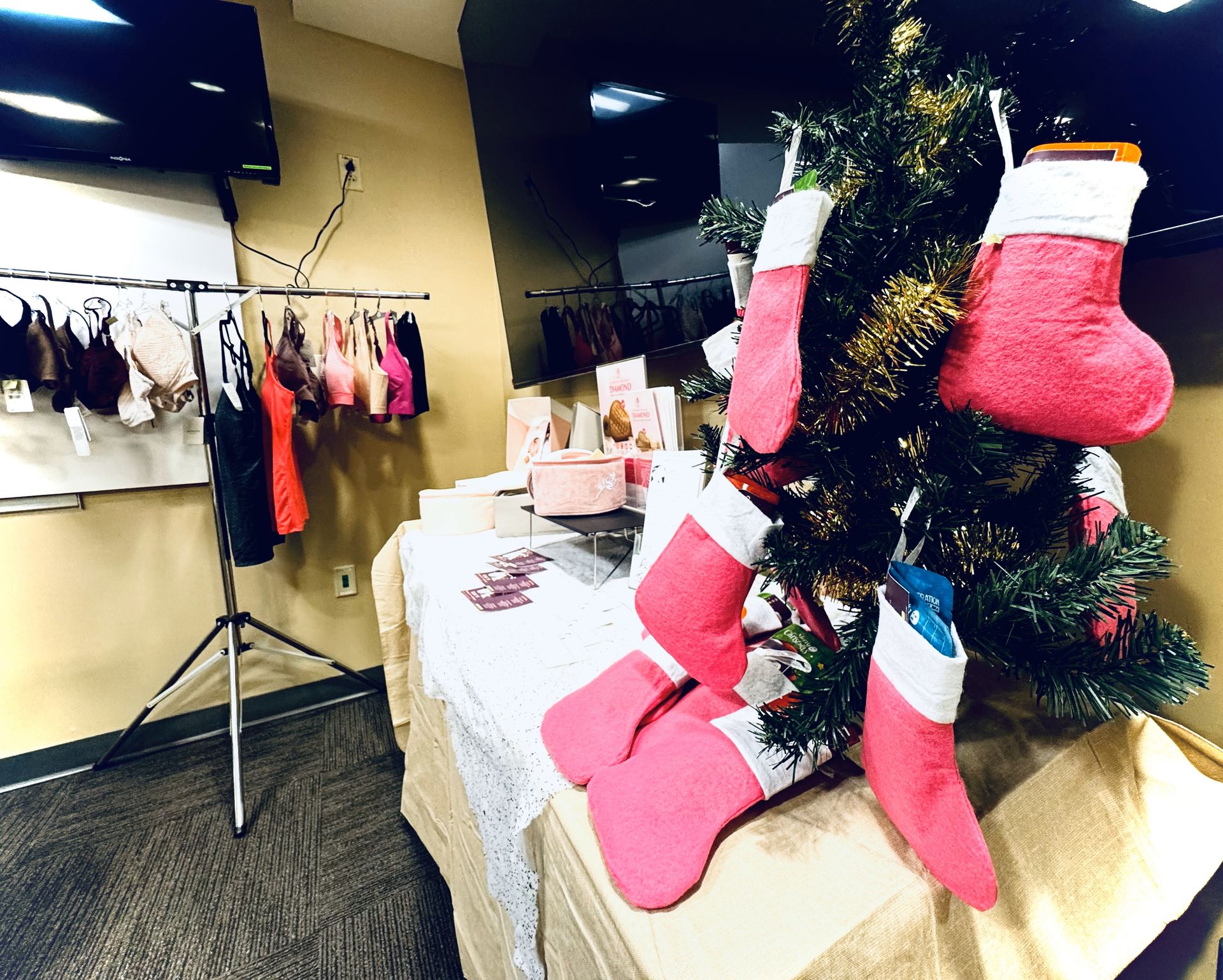 A christmas tree with pink and white stockings hanging from it
