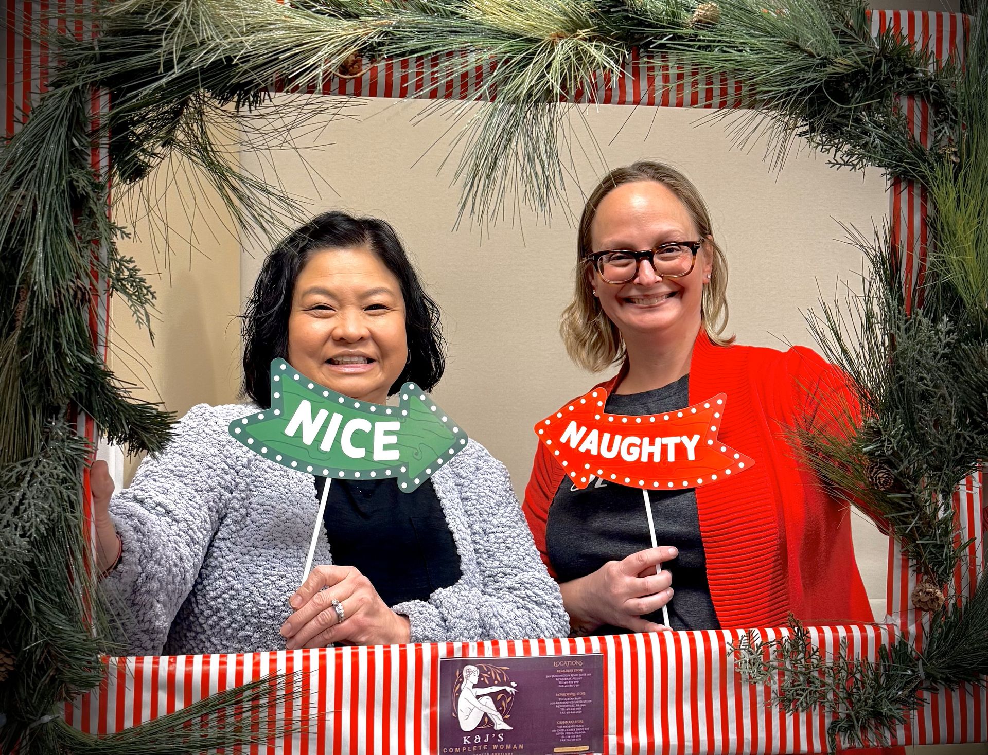 Two women are posing for a picture with christmas props.