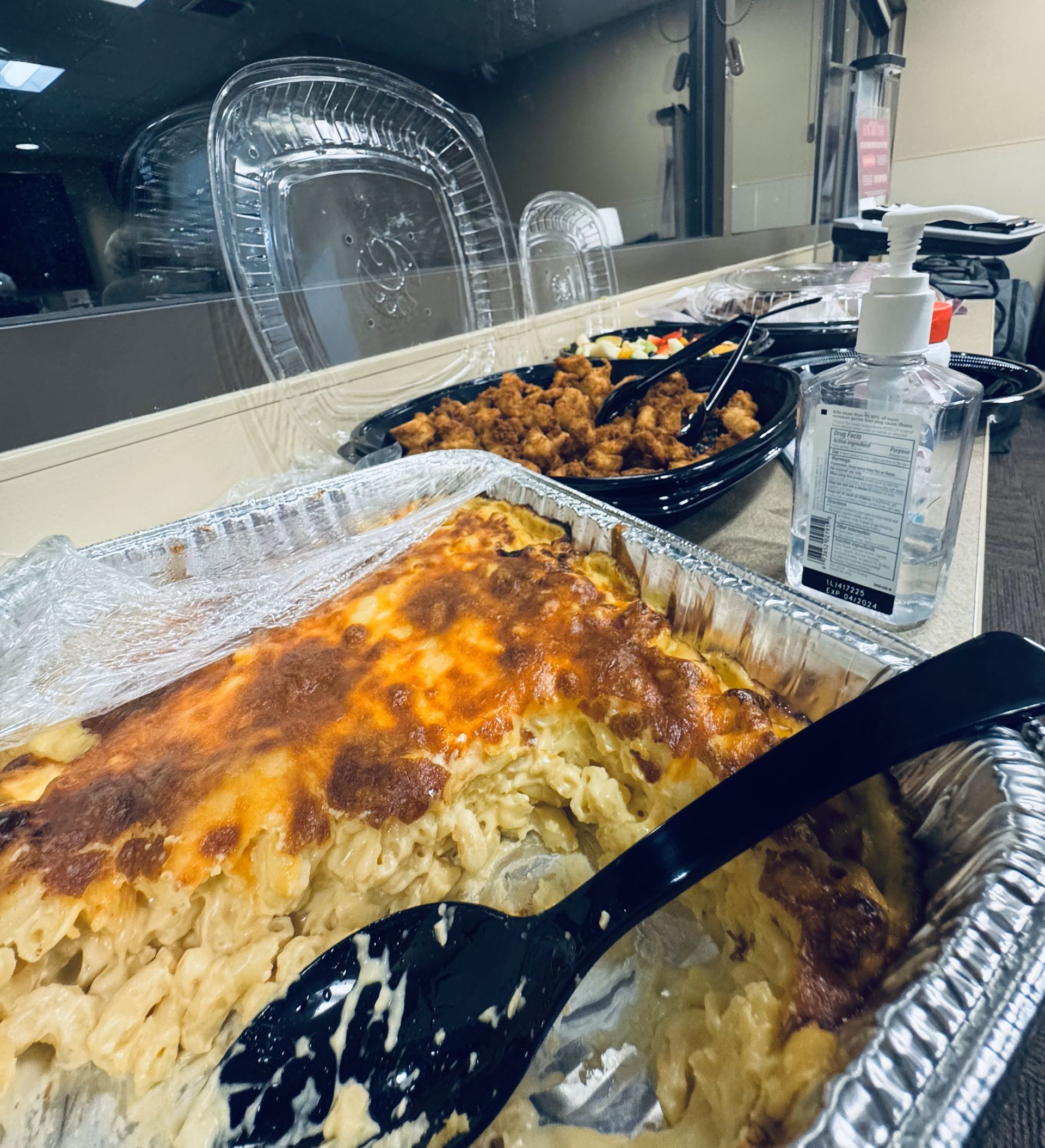 A tray of macaroni and cheese with a spoon in it is sitting on a table.