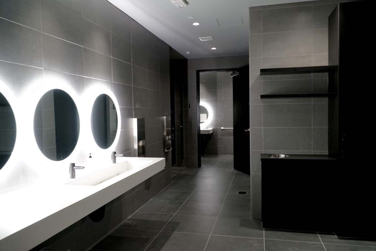 A bathroom with a row of sinks and mirrors