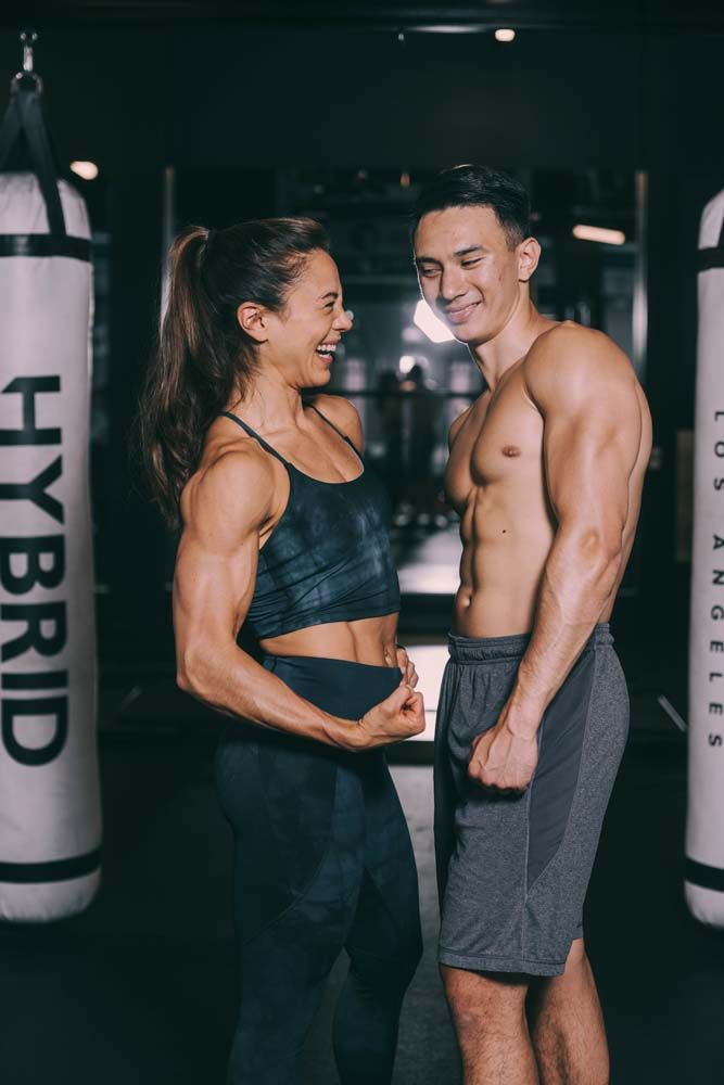 A man and a woman are standing next to each other in a gym.