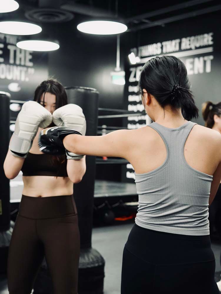 A group of women are boxing in a gym.