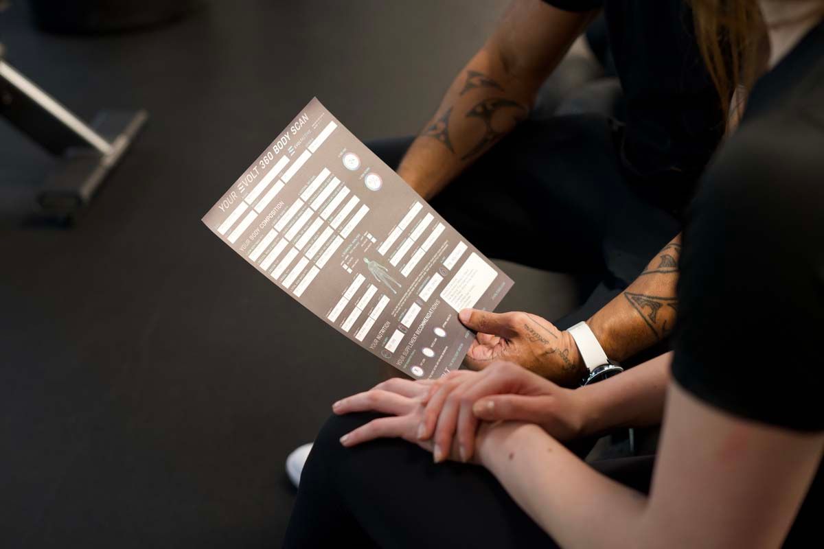 A man and a woman are sitting next to each other looking at a menu.