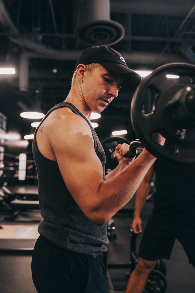 A man is lifting a barbell in a gym.