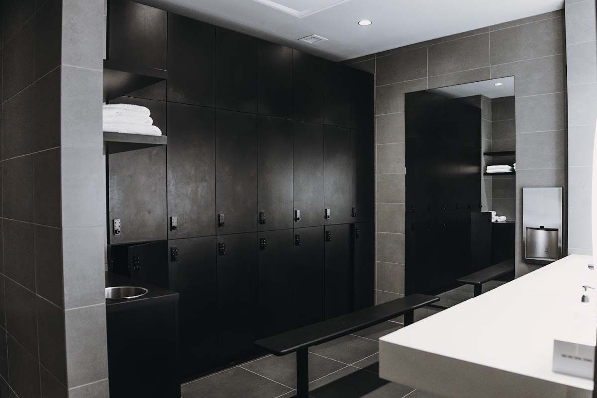 A locker room with black cabinets and a bench