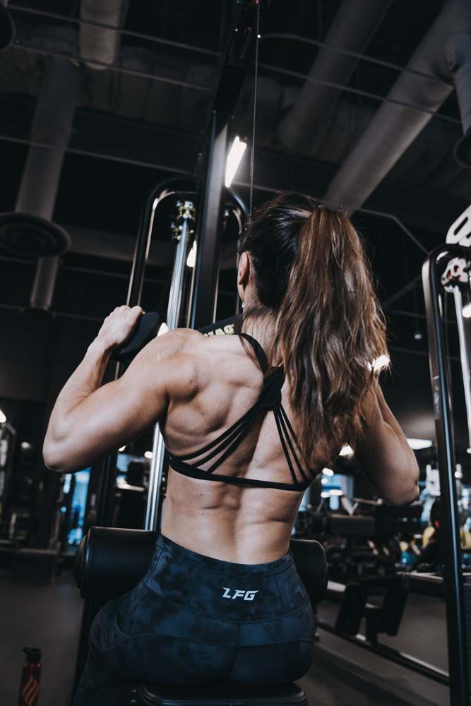 A woman is doing exercises on a machine in a gym.