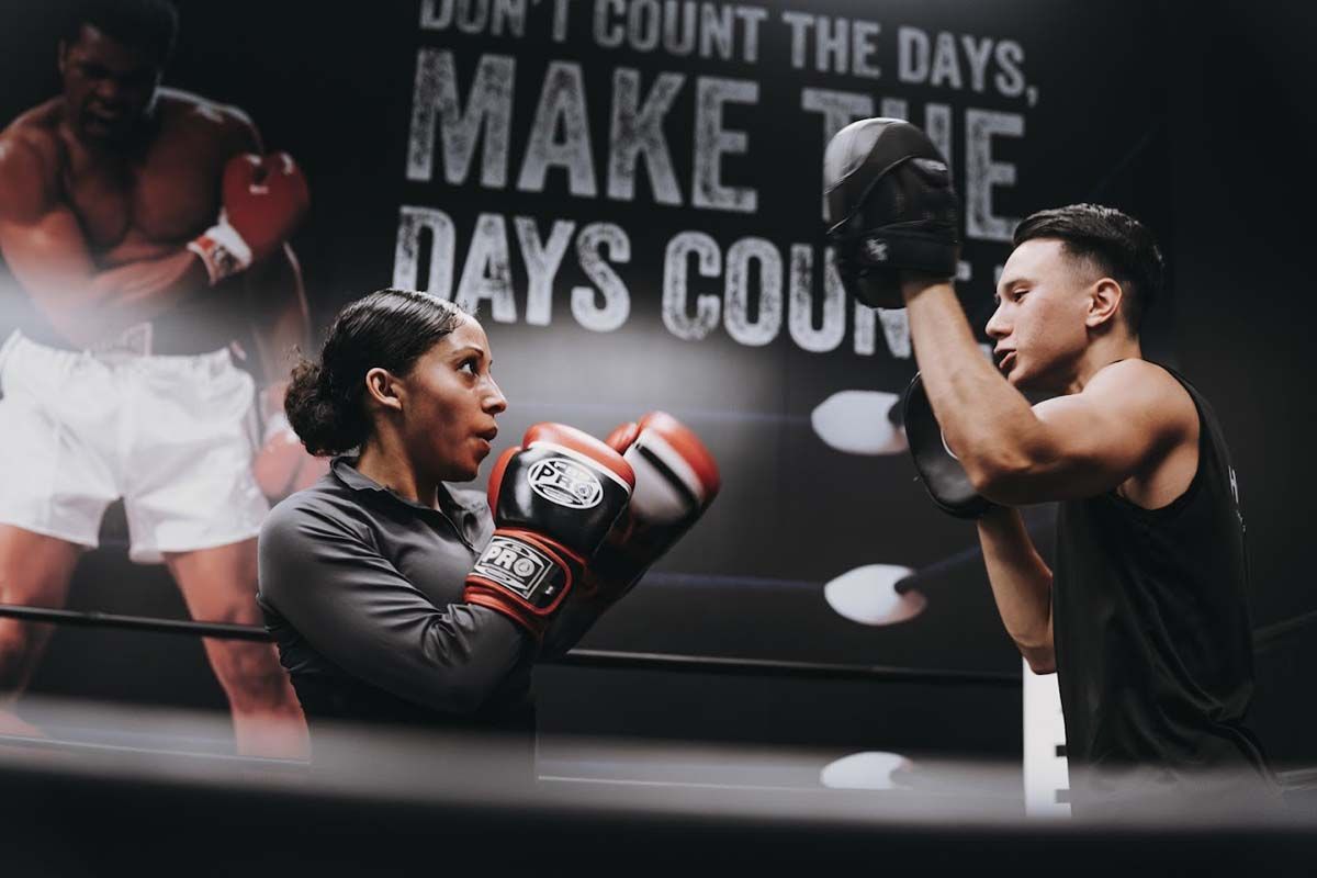 A man and a woman are boxing in a ring.
