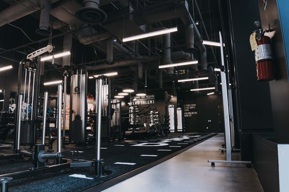 An empty gym with a fire extinguisher on the wall.