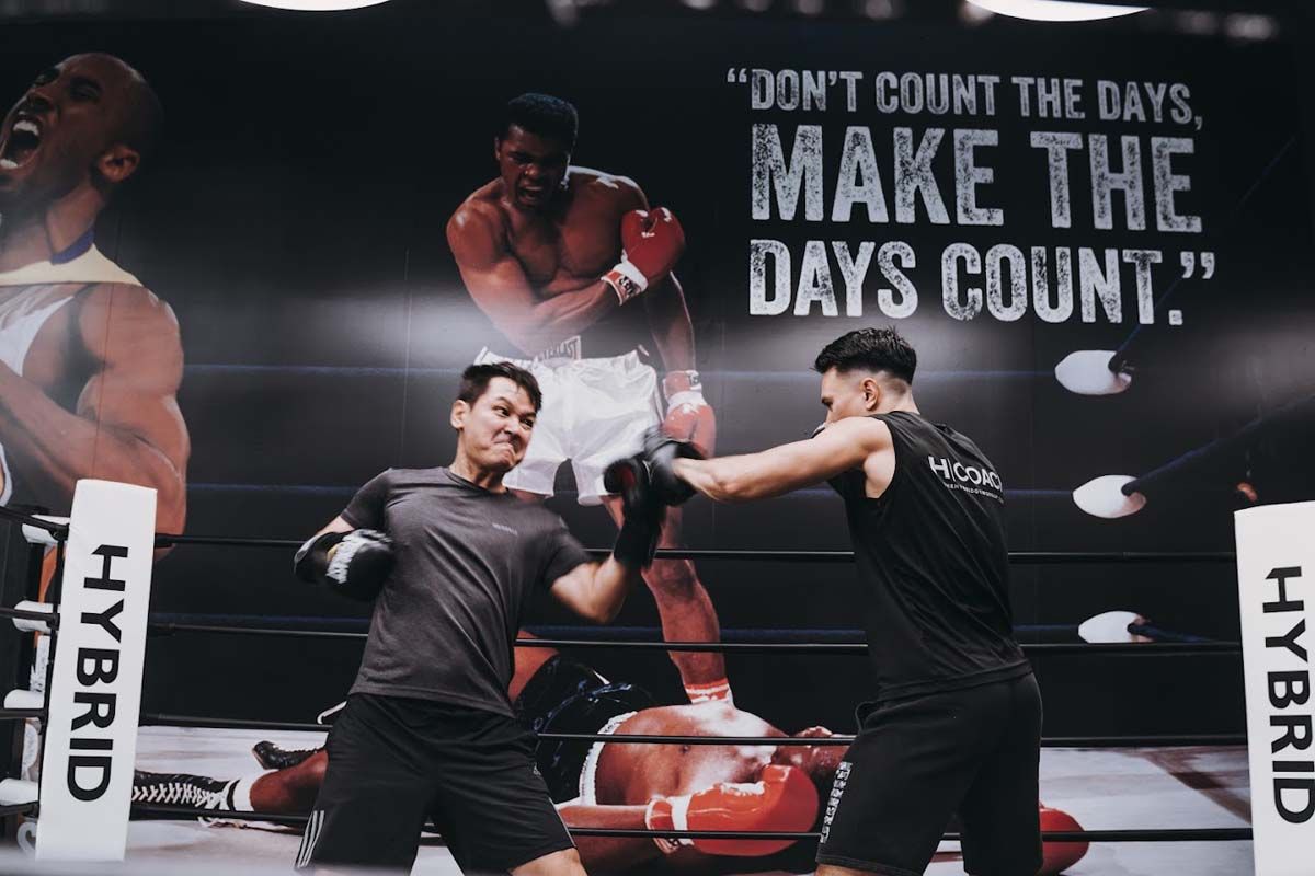 Two men are boxing in a ring with a quote that says