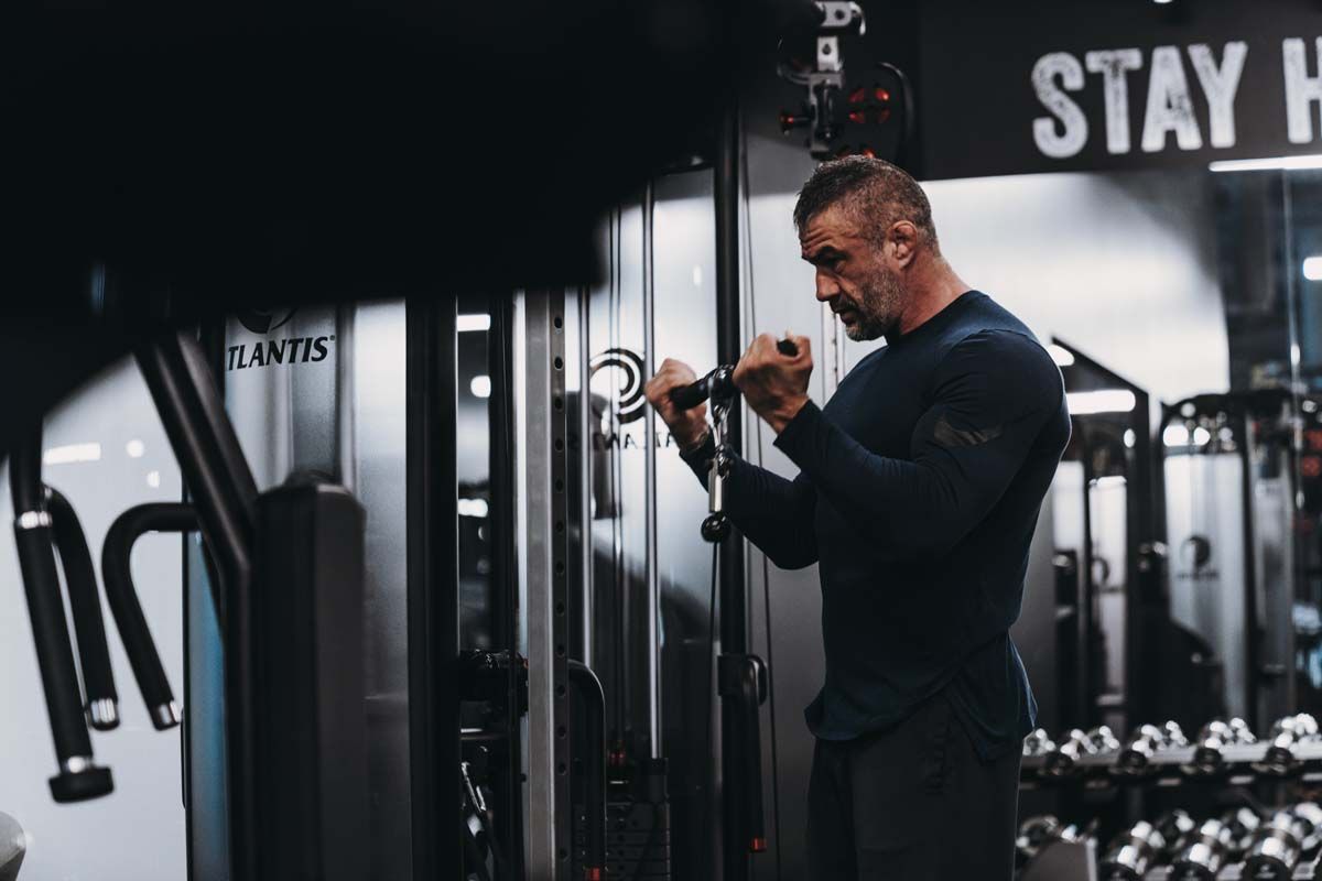A man is using a machine in a gym.