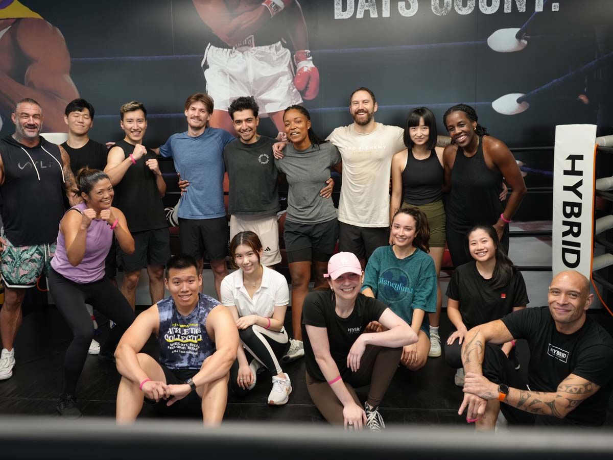 A group of people are posing for a picture in front of a boxing ring.