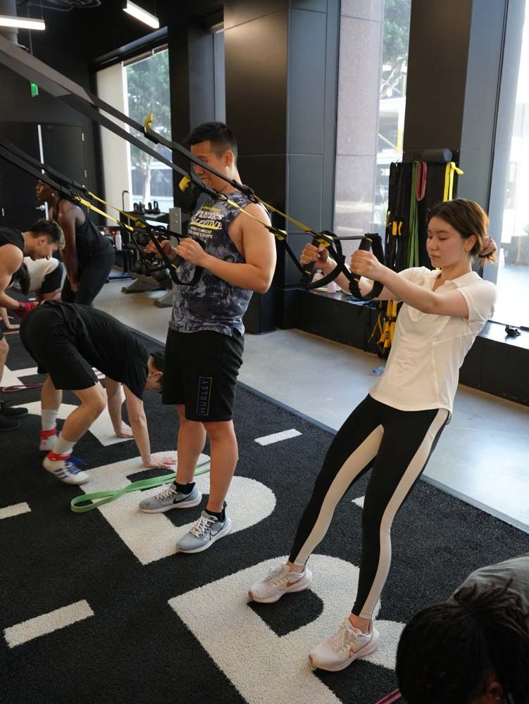 A group of people are doing exercises in a gym.
