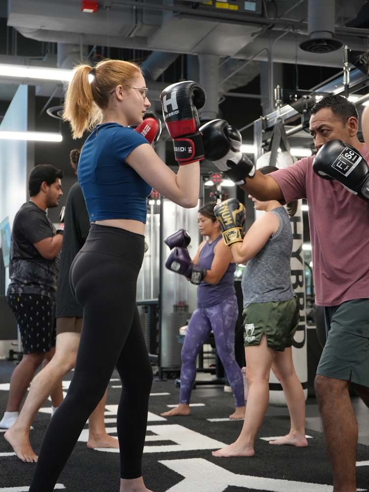 A group of people are practicing boxing in a gym
