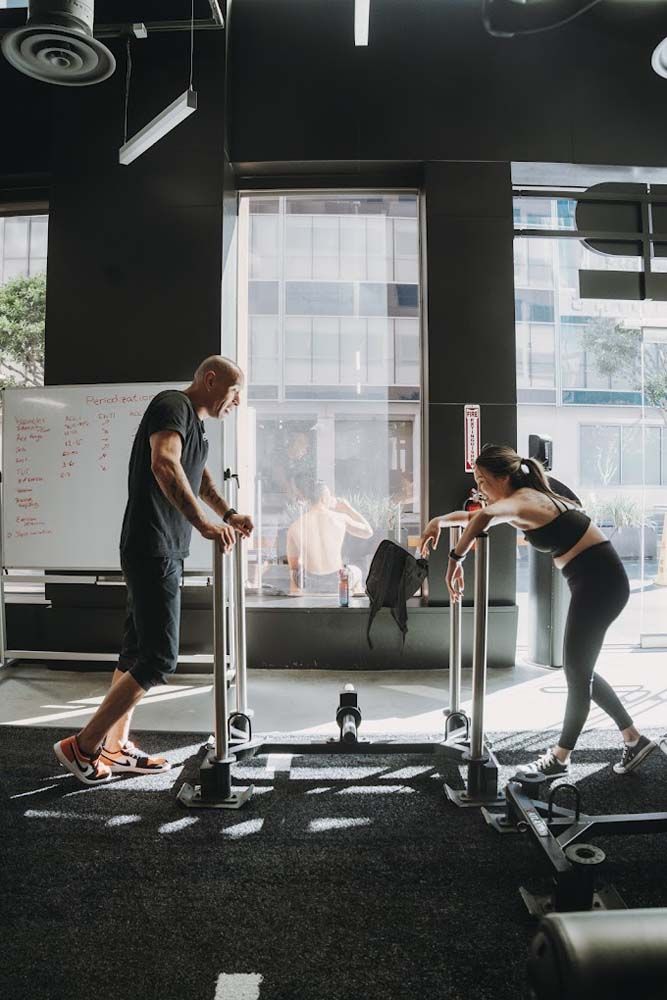 A man and a woman are standing next to each other in a gym.