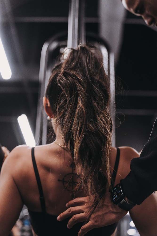 A woman is getting a massage from a man in a gym.