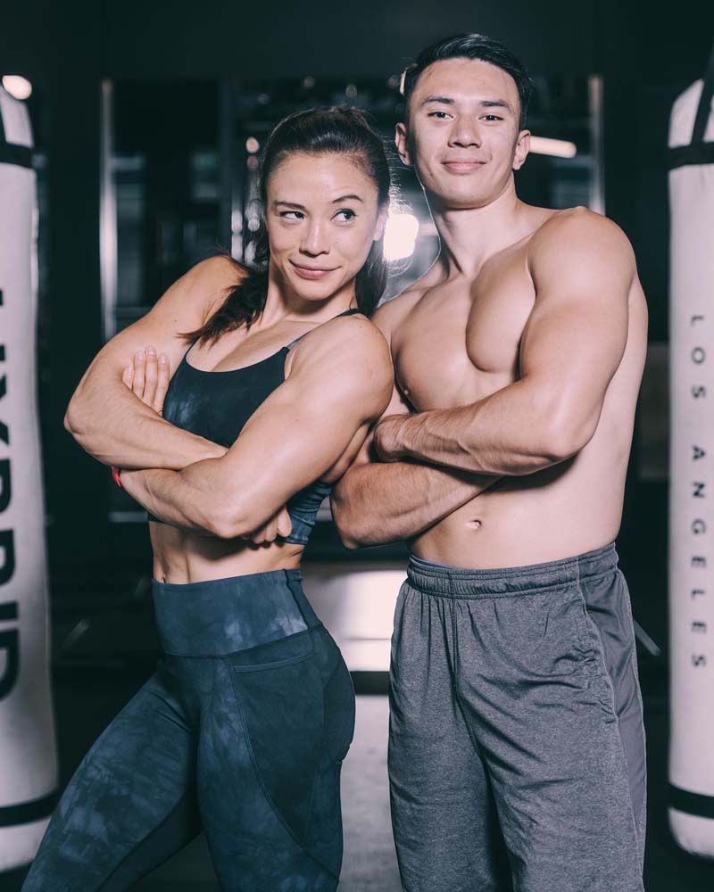 A man and a woman are posing for a picture in a gym.