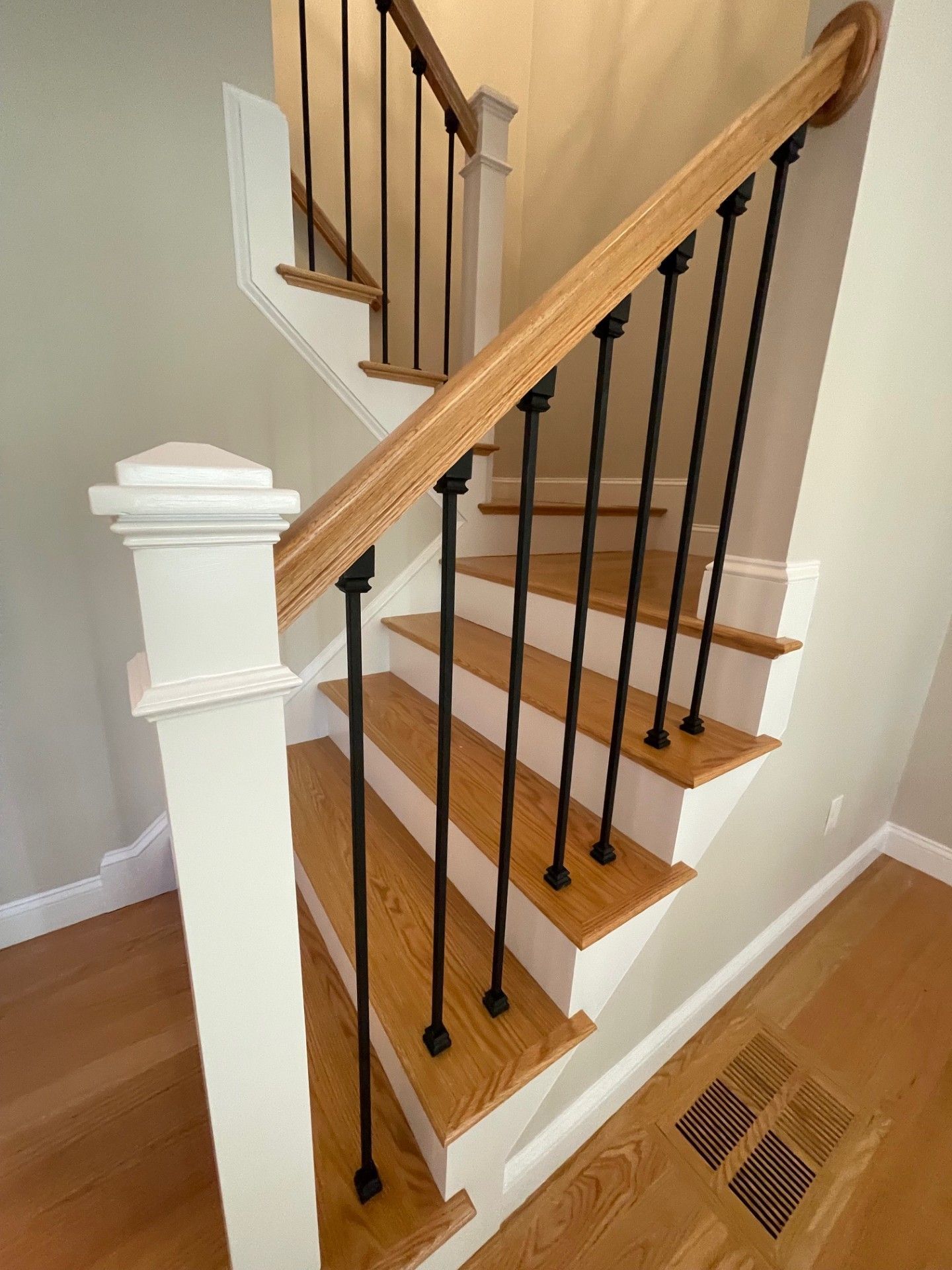 A staircase with wooden steps and black railings in a house.