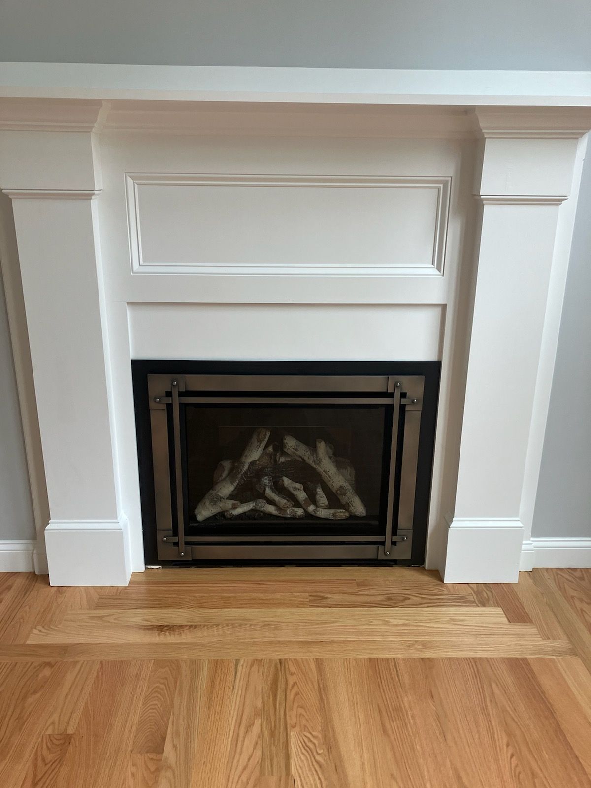 A fireplace with a wooden floor in a living room.