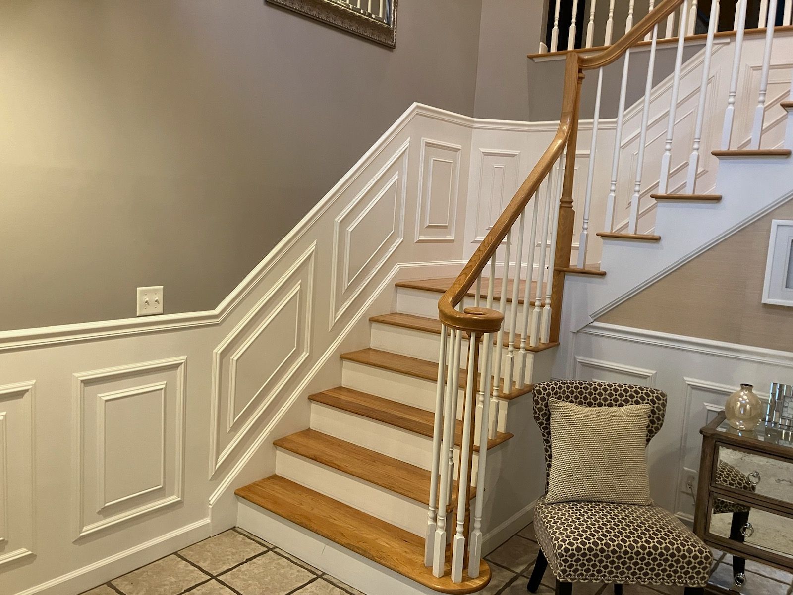 A staircase with wooden steps and a white railing in a living room.