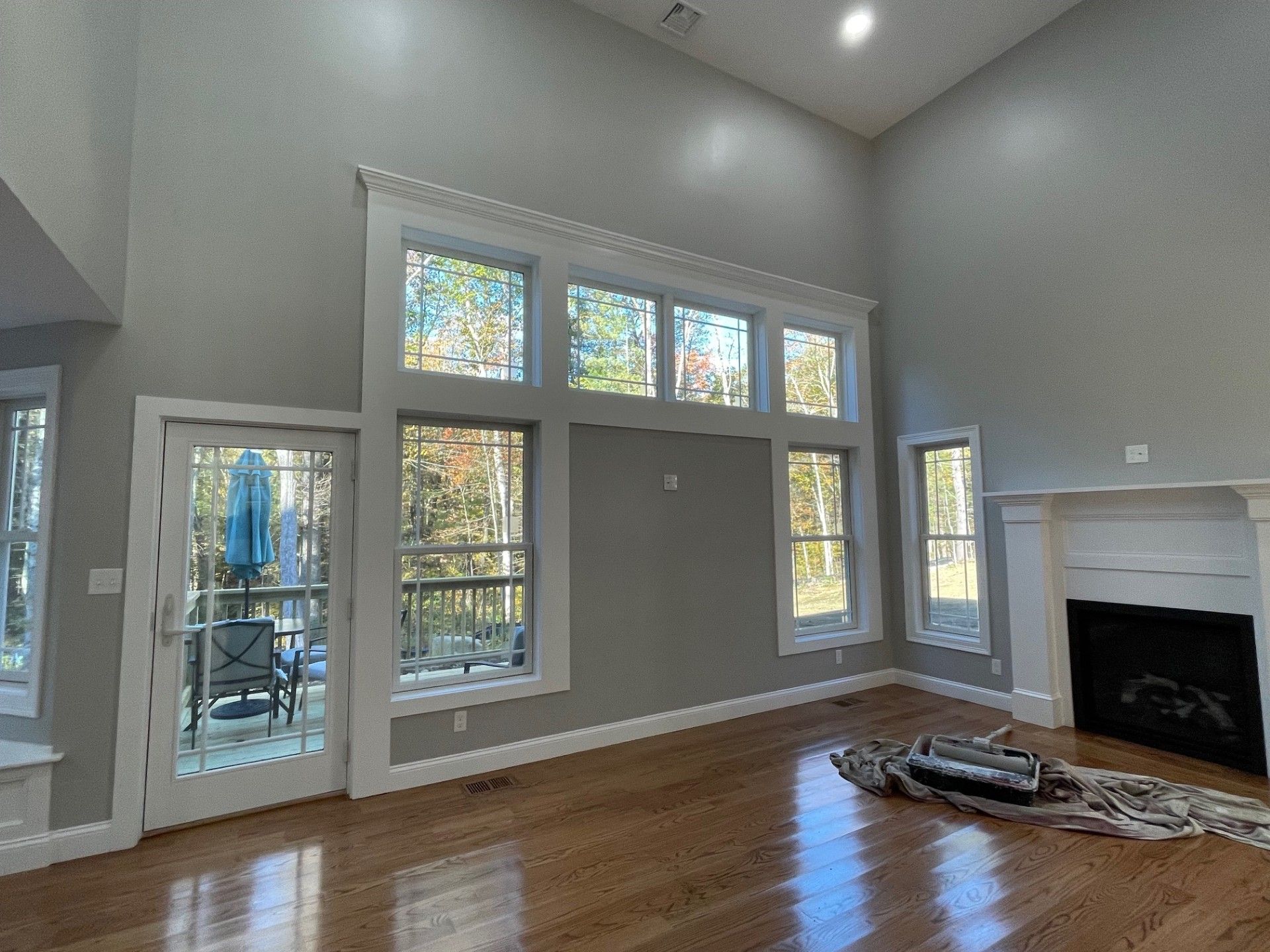 An empty living room with a fireplace and lots of windows