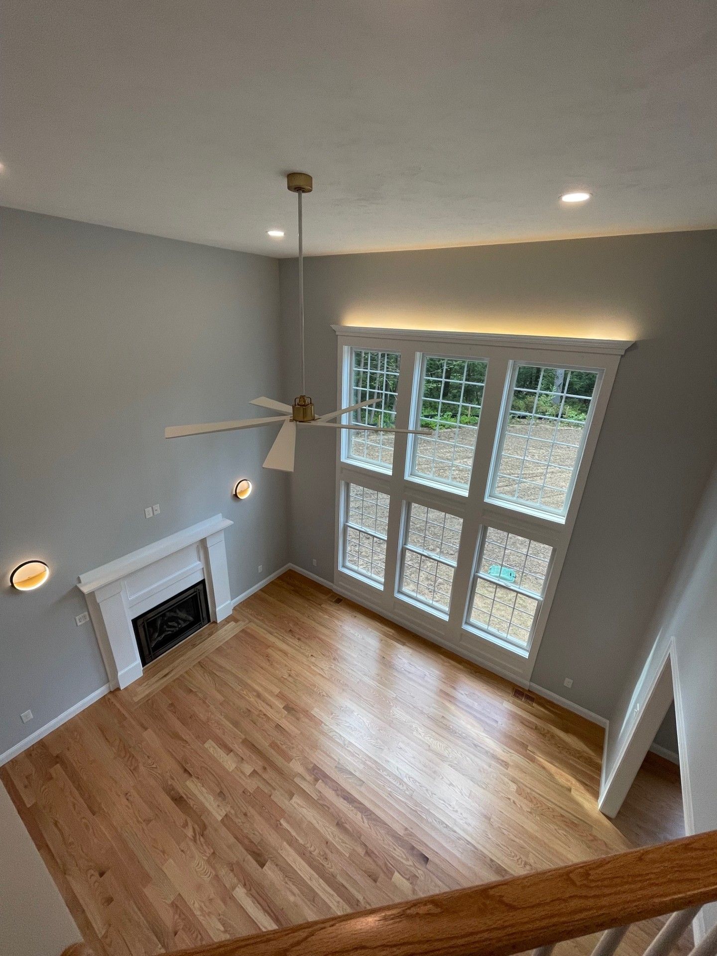 An aerial view of a living room with hardwood floors and a ceiling fan.