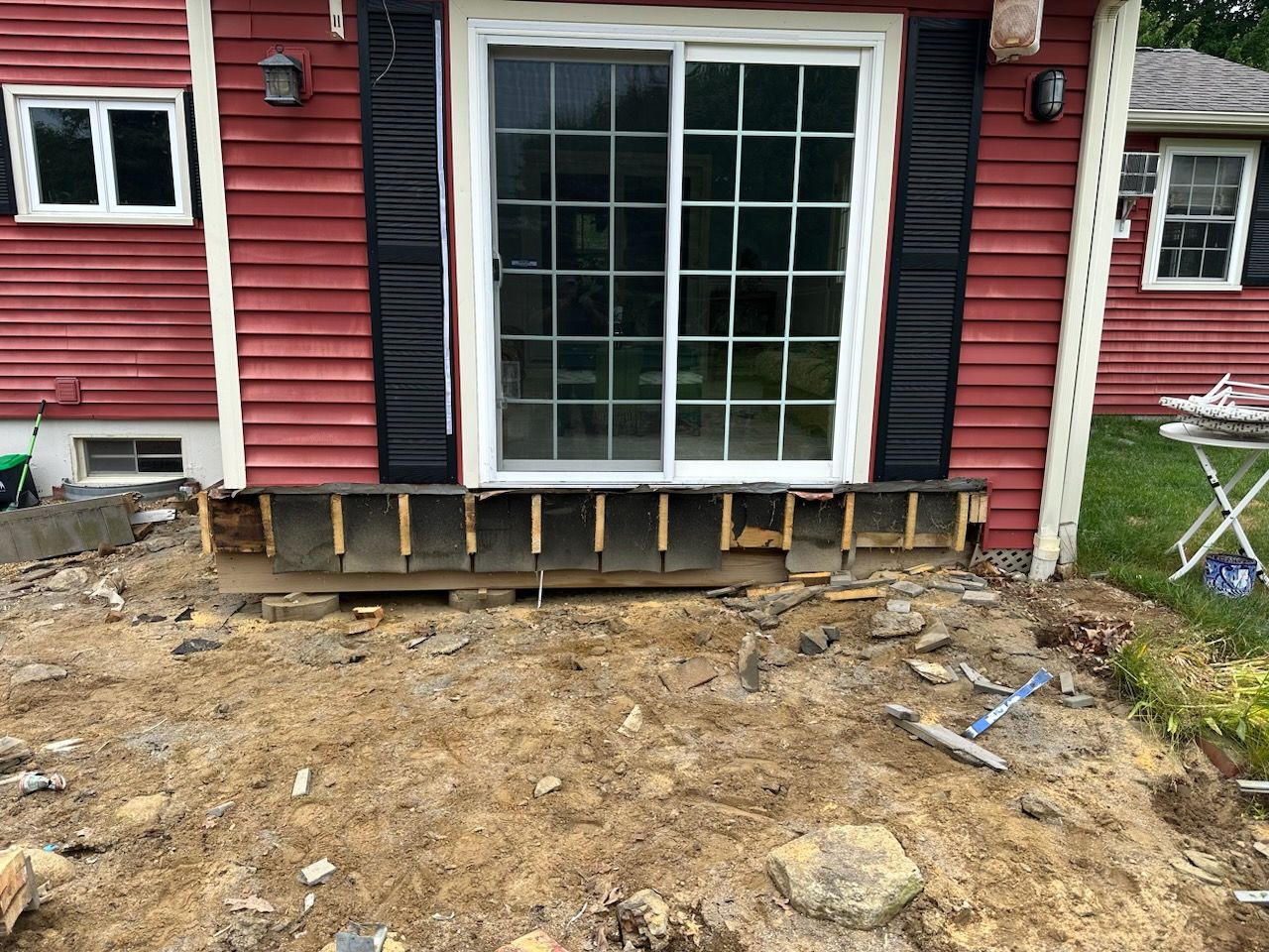 A red house with a sliding glass door is being remodeled.