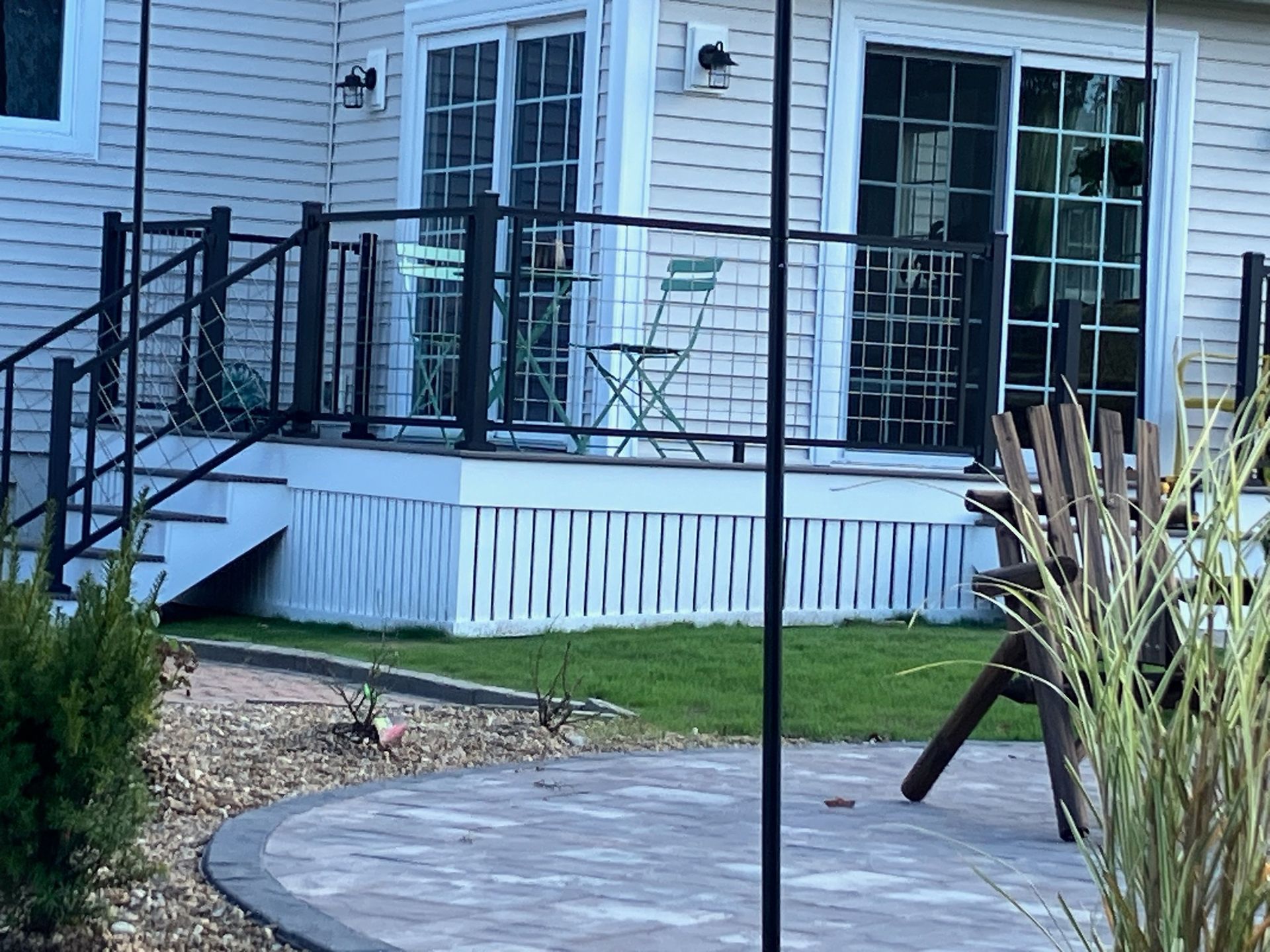 A white house with a patio and stairs leading up to it.