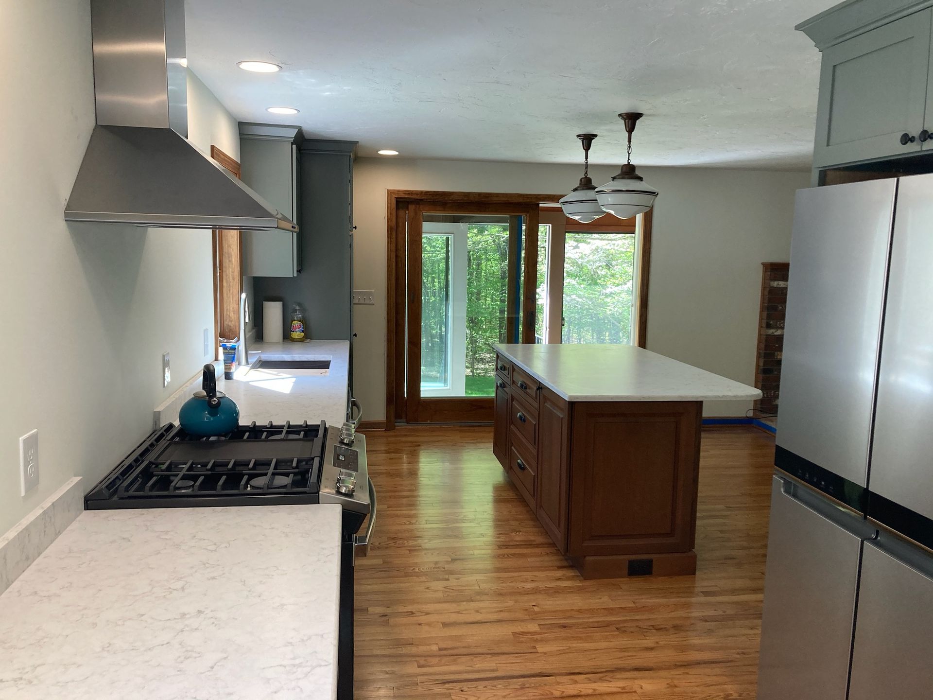 A kitchen with stainless steel appliances and a large island.