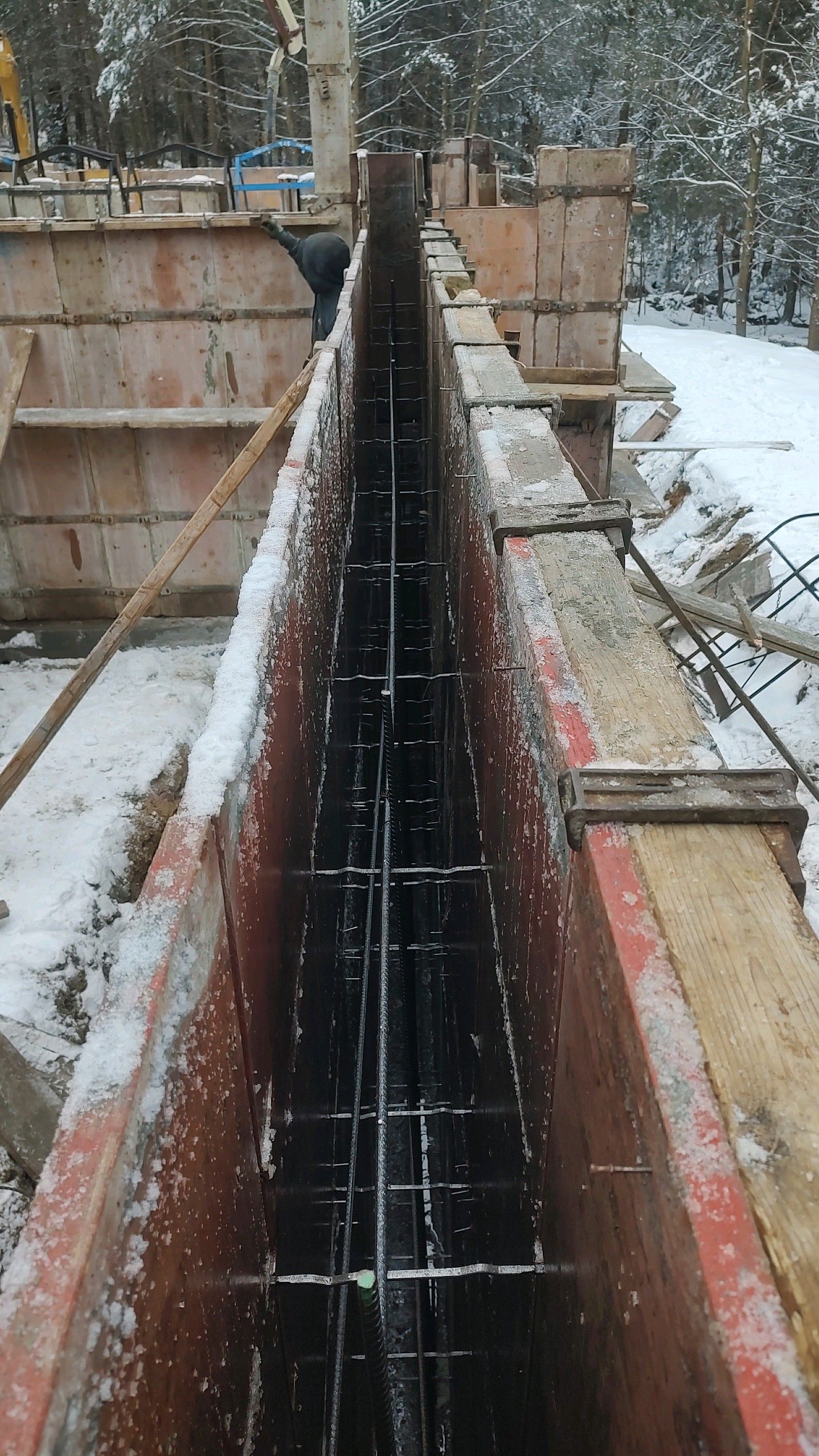 A concrete wall is being built in the snow.