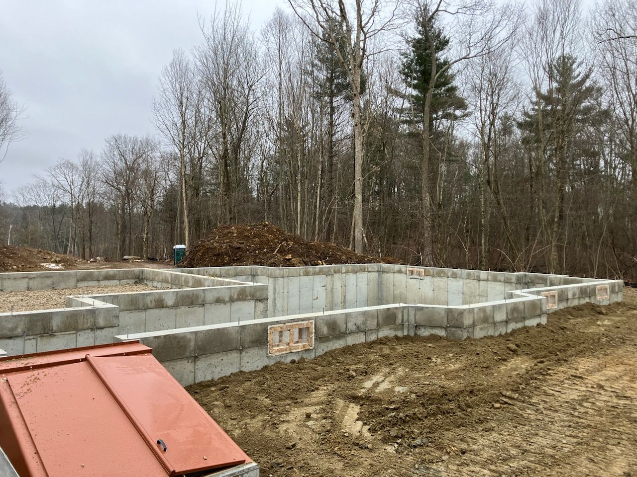 A concrete foundation is being built in the middle of a forest.