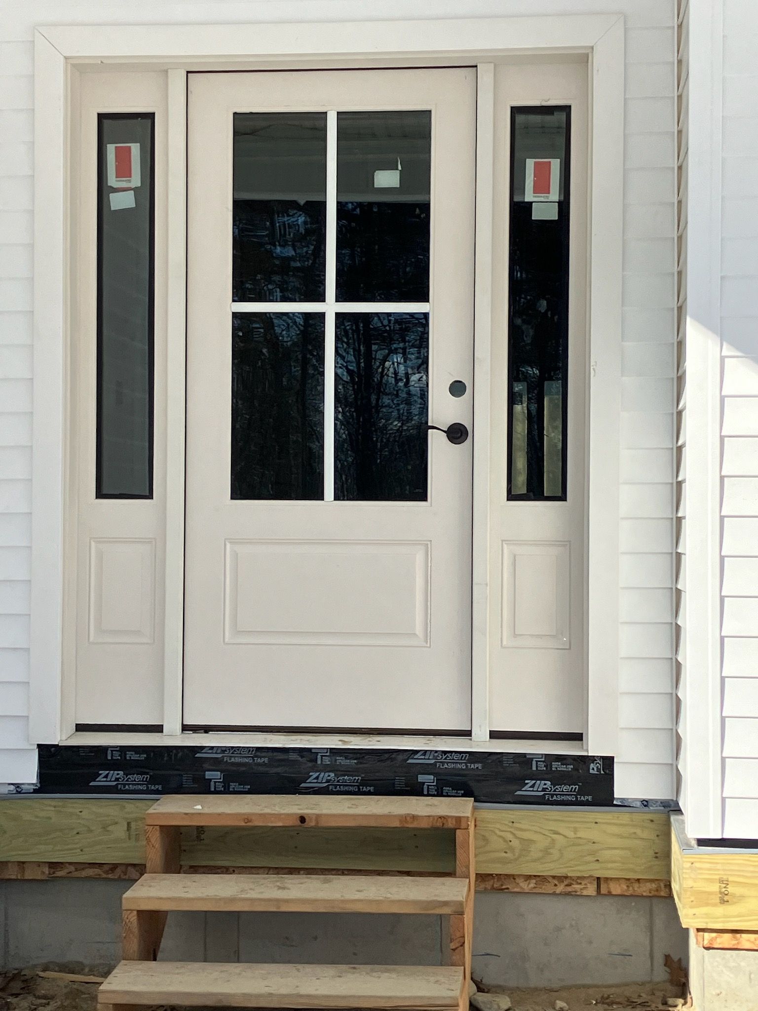 The front door of a white house with stairs leading up to it