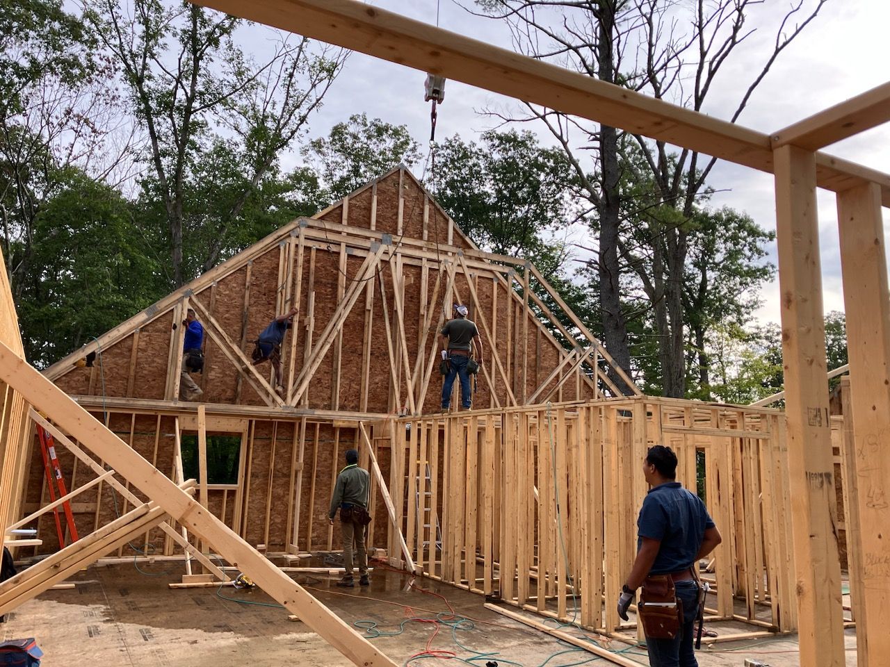 A group of construction workers are working on a house under construction.