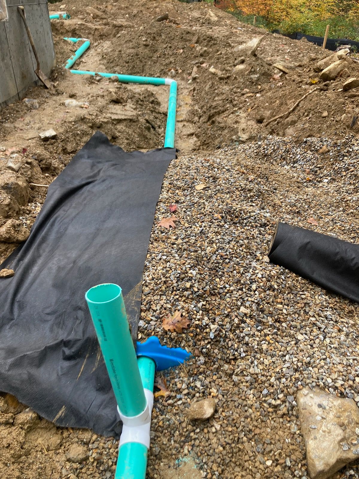 A bunch of pipes are sitting on top of a pile of gravel.