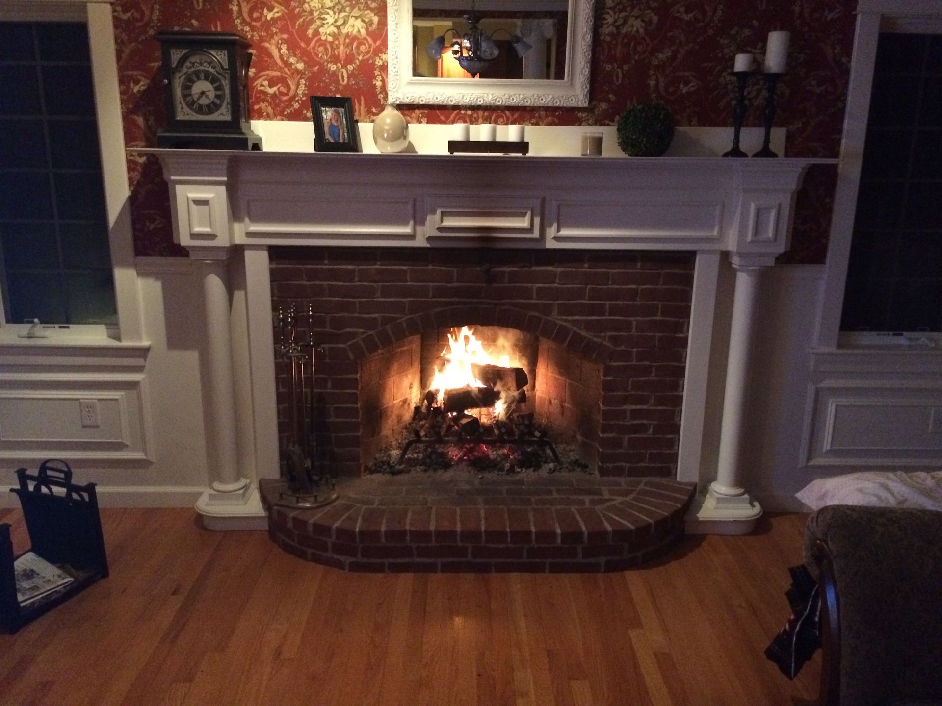 A living room with a fireplace and a clock on the mantle