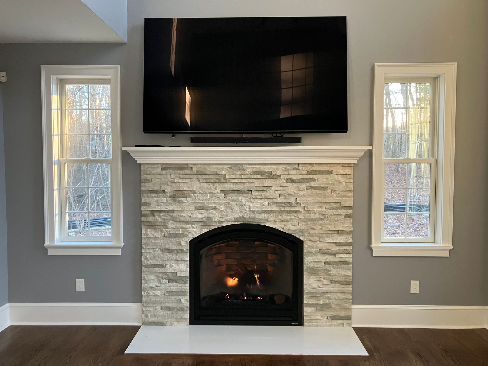 A living room with a fireplace and a flat screen tv above it.