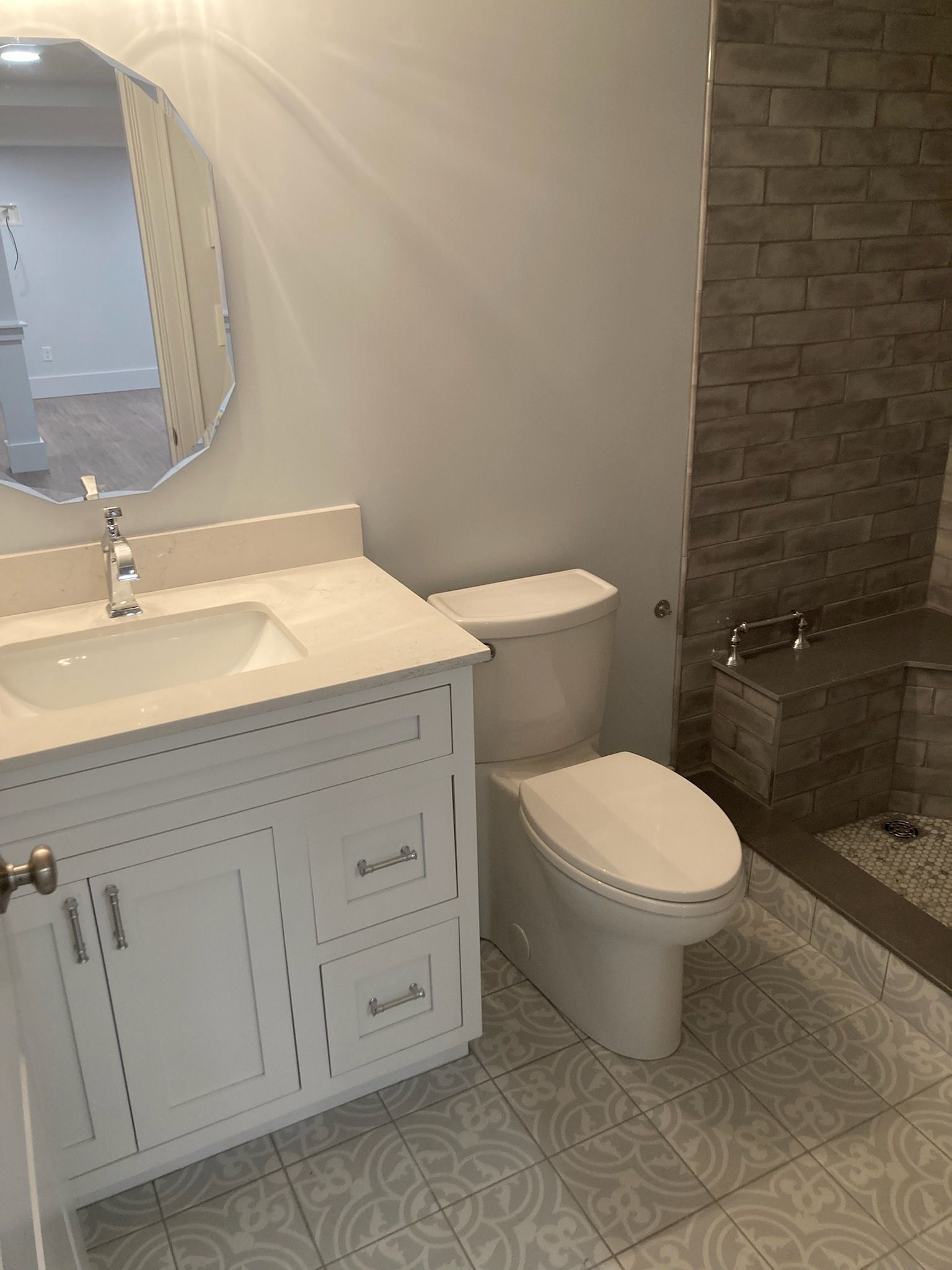 A bathroom with a toilet, sink, and mirror.