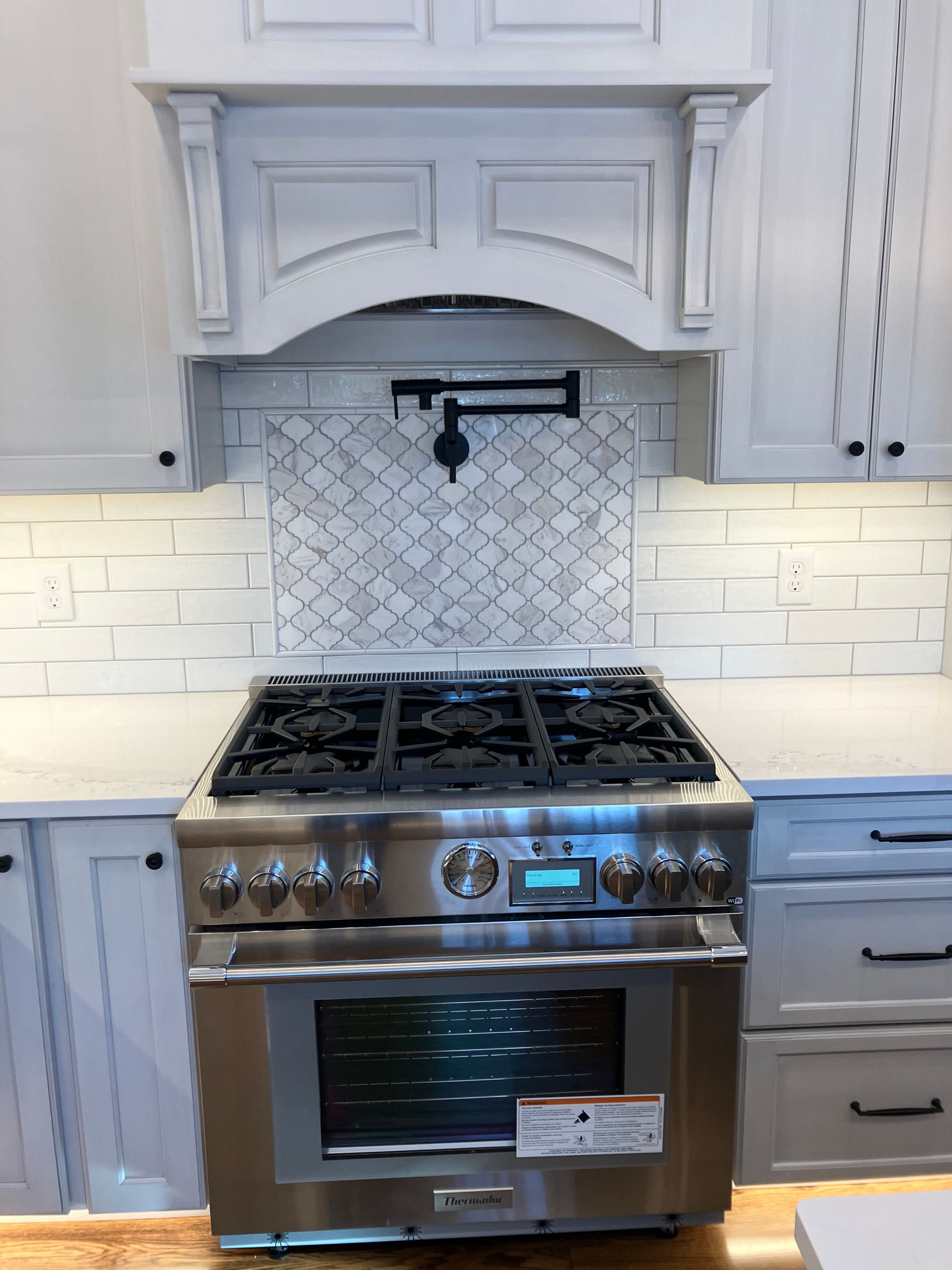 A stainless steel stove top oven is sitting on top of a wooden counter in a kitchen.