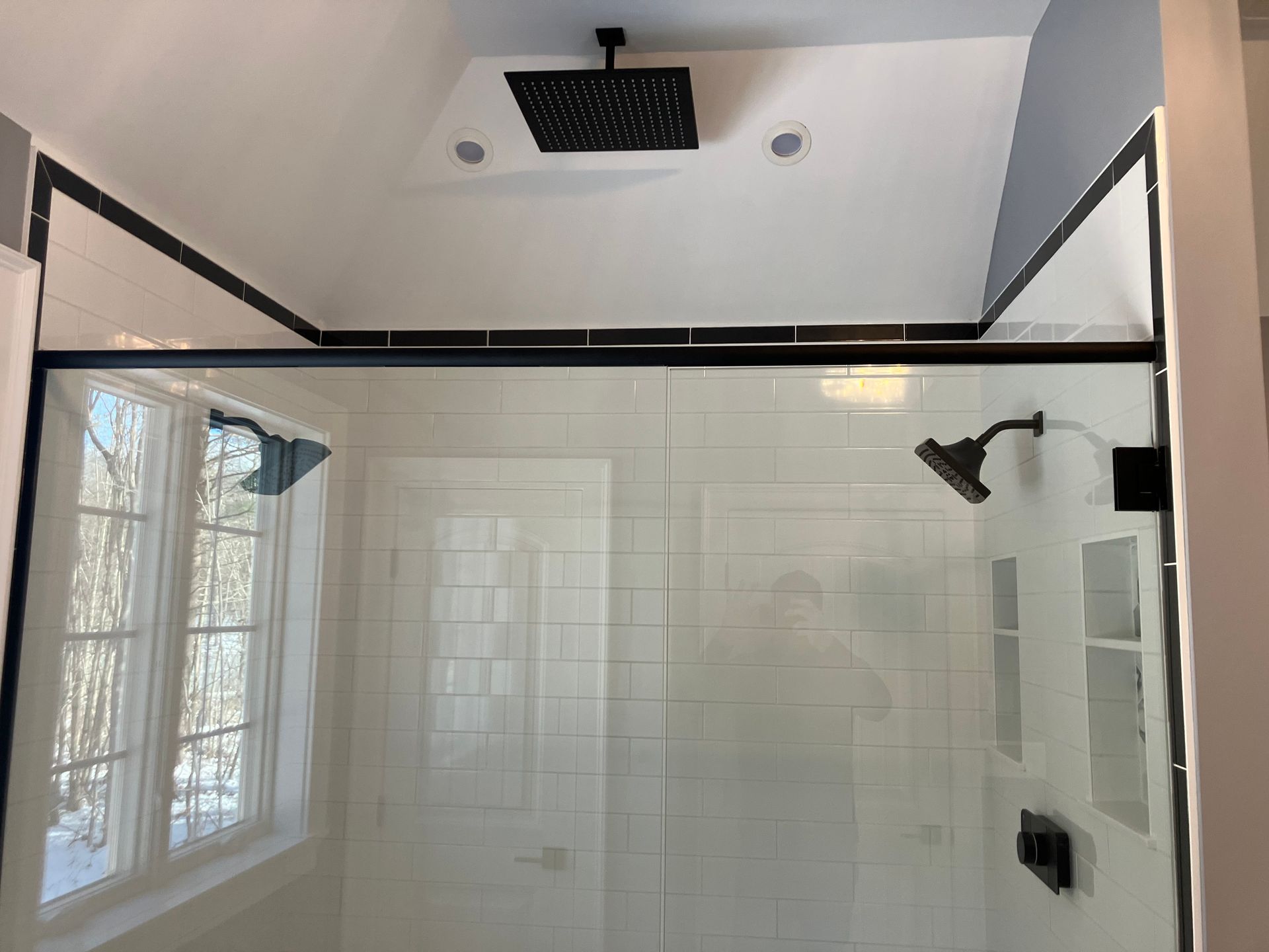 A bathroom with a walk in shower and a rain shower head.