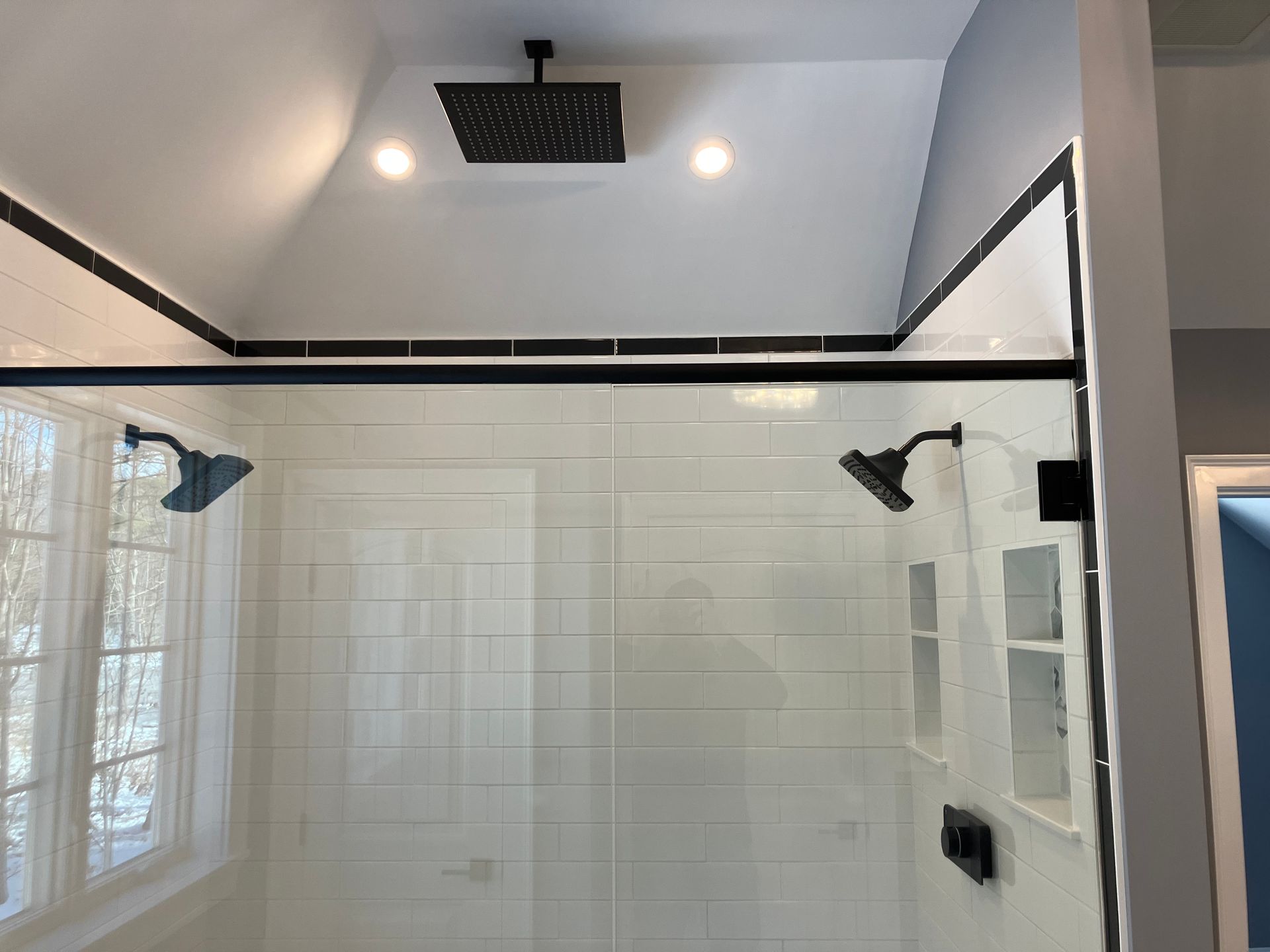 A bathroom with a walk in shower and a rain shower head.