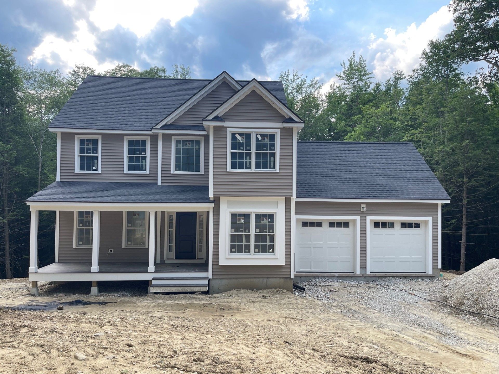 A large house with a porch and two garage doors