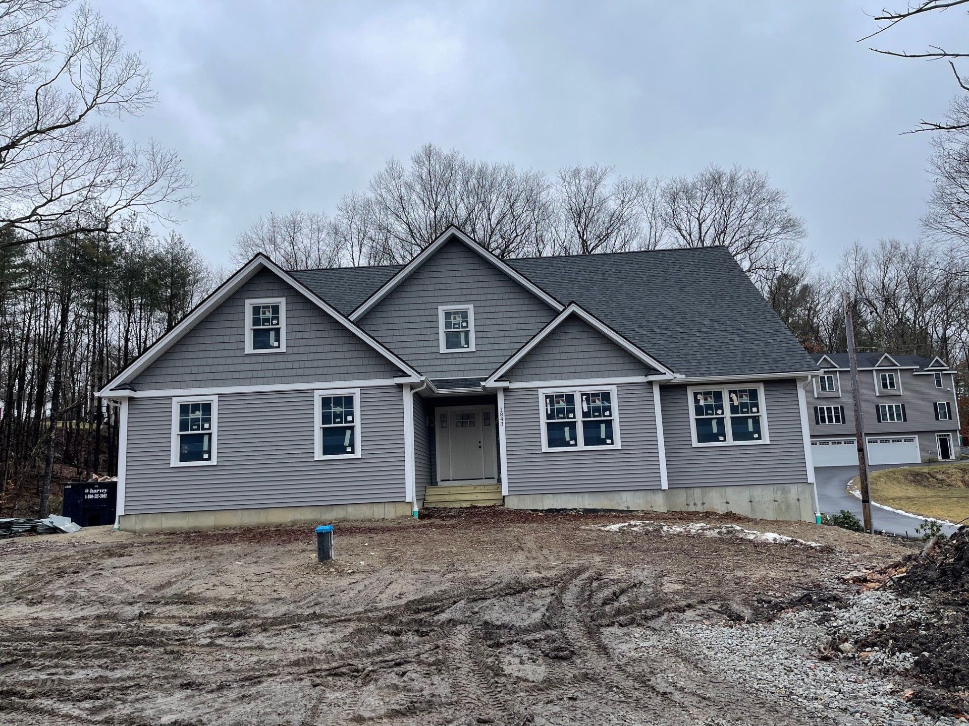 A large house with a lot of windows is sitting on top of a dirt hill.