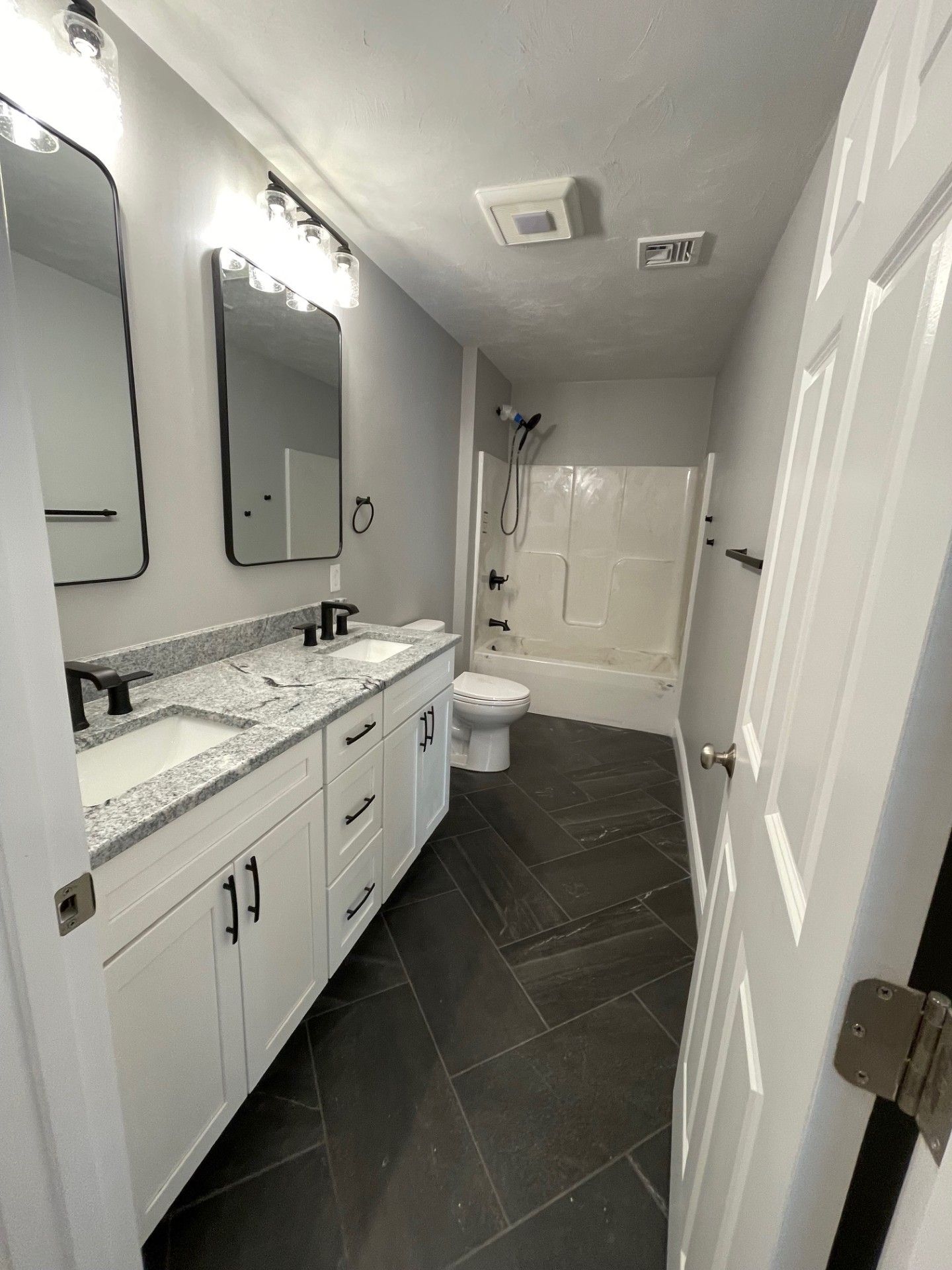 A bathroom with two sinks, a toilet, and a bathtub.