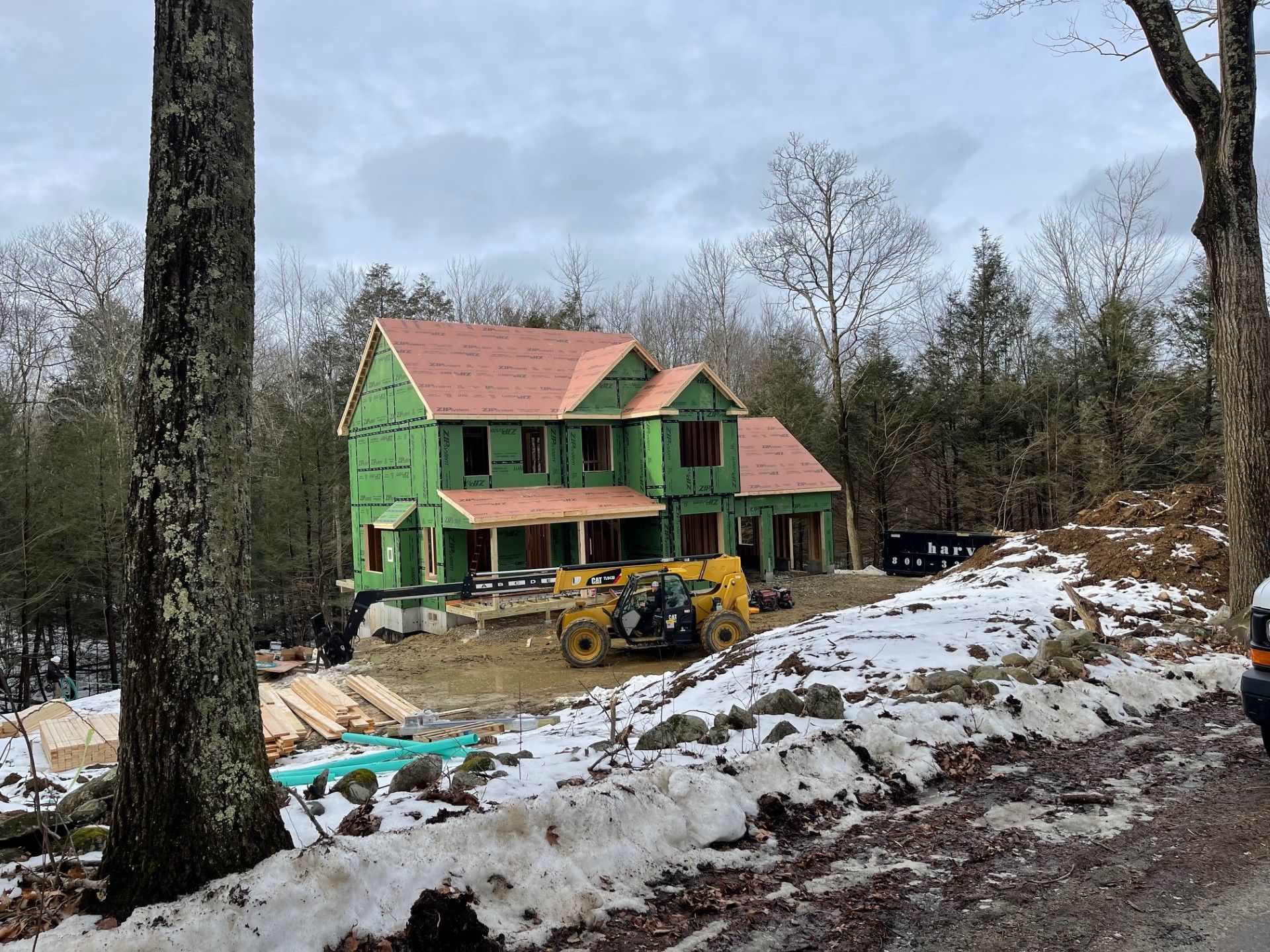 A house is being built in the middle of a snowy forest.