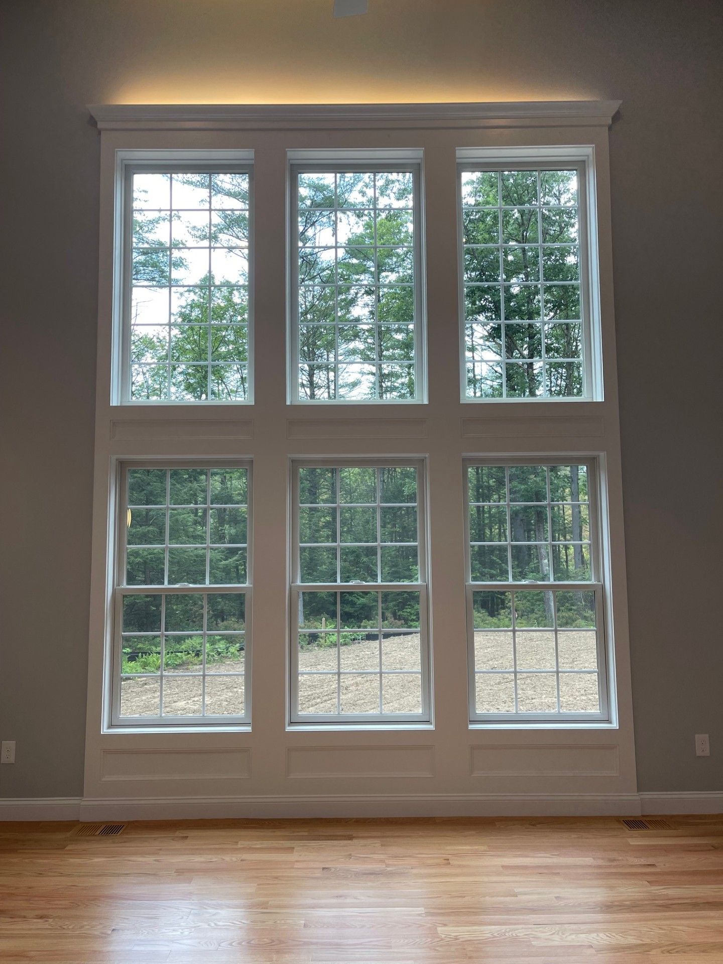 A room with a lot of windows and a wooden floor