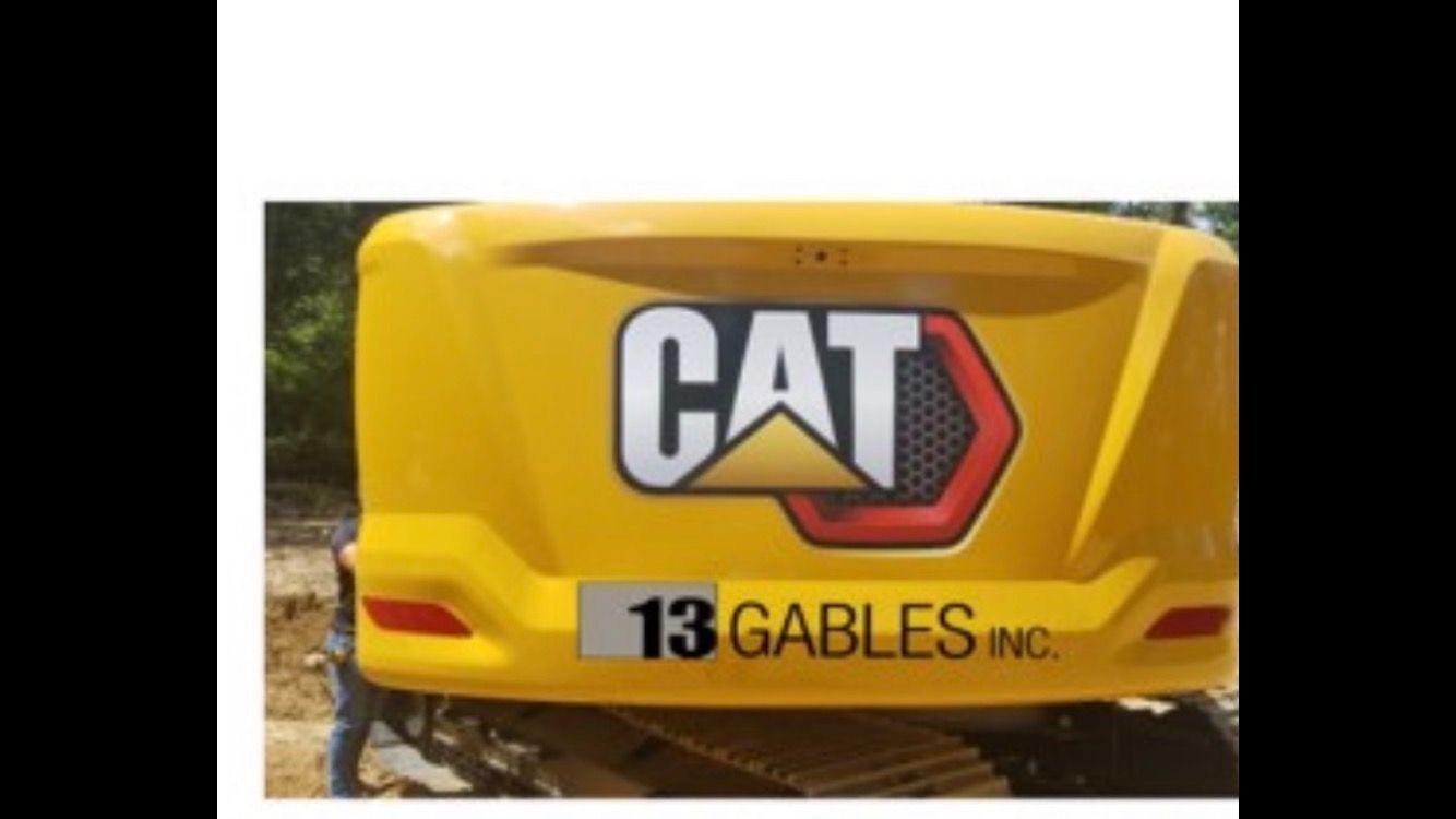 A yellow cat truck is parked in the dirt