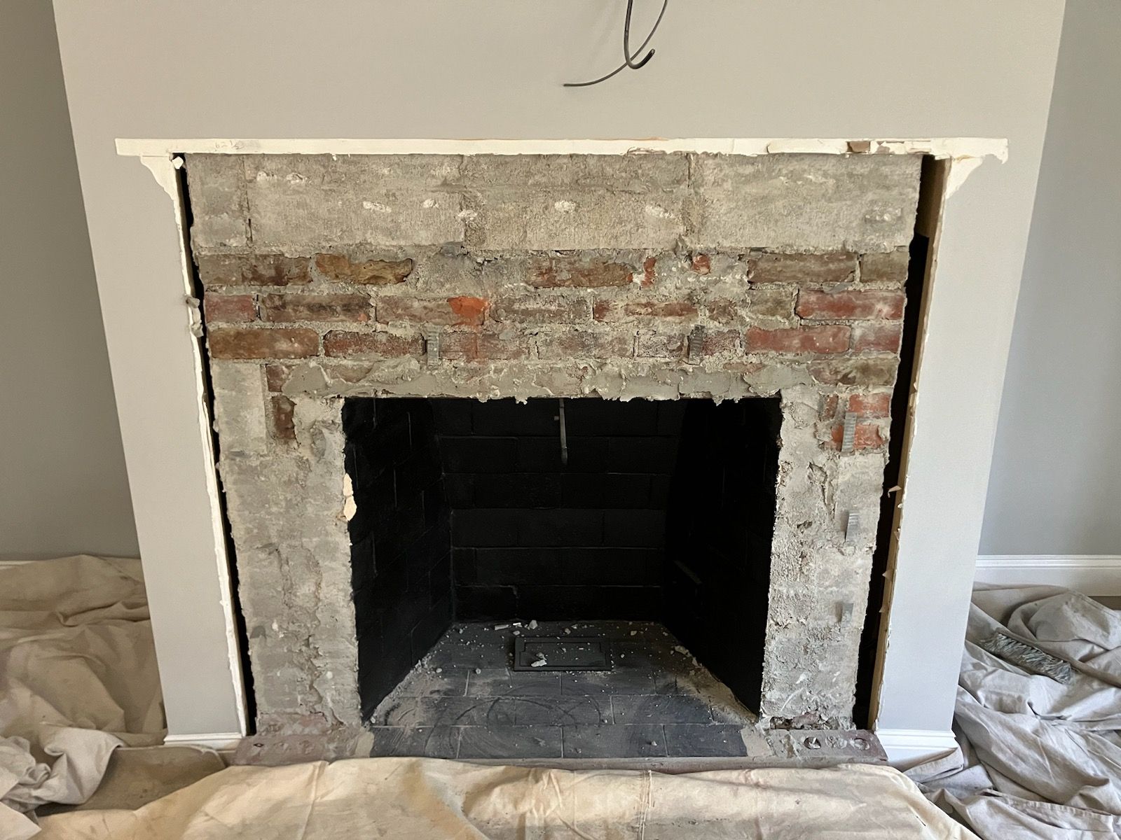 A brick fireplace is being remodeled in a living room.